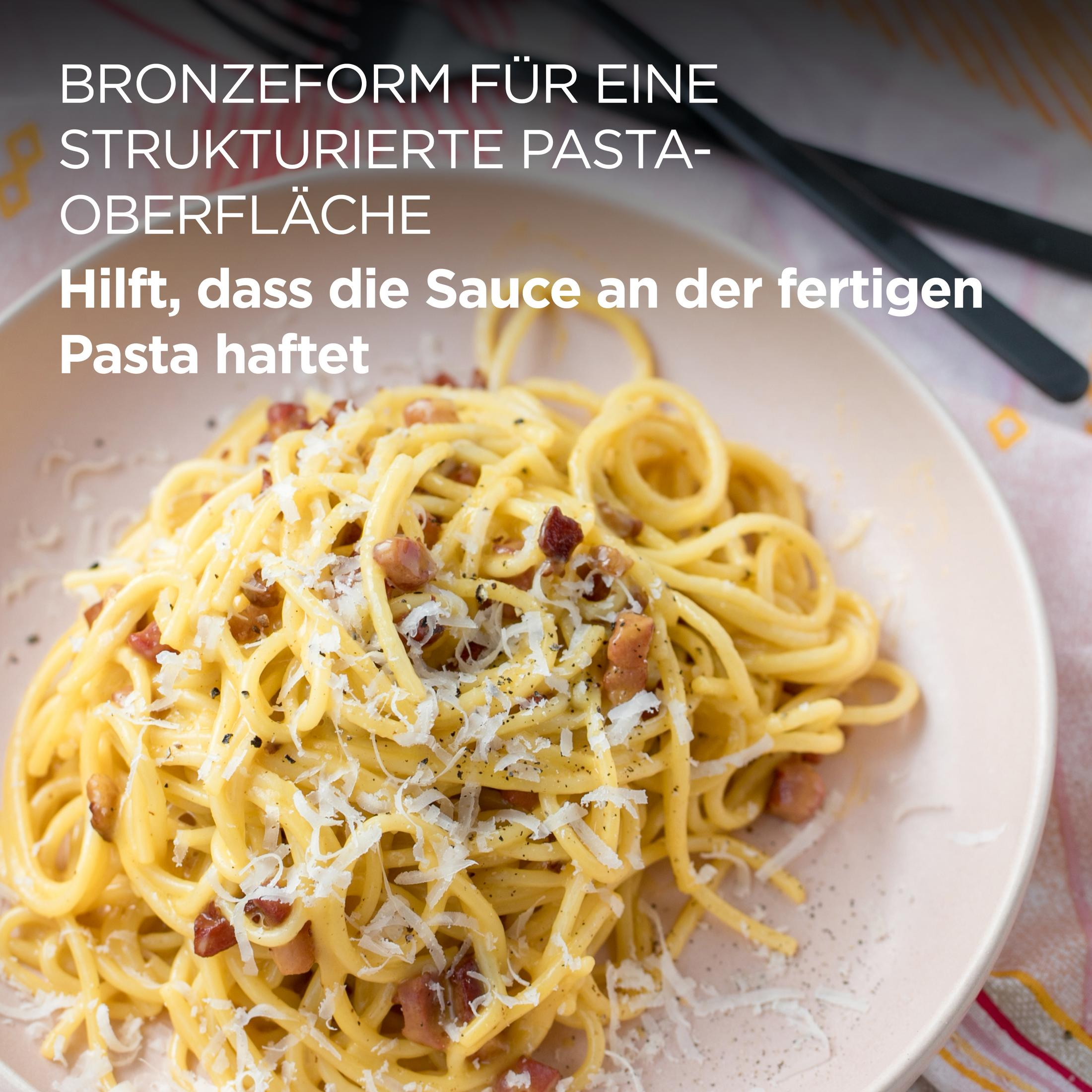 Spaghetti Carbonara mit Speck und Käse auf einem hellrosa Teller.