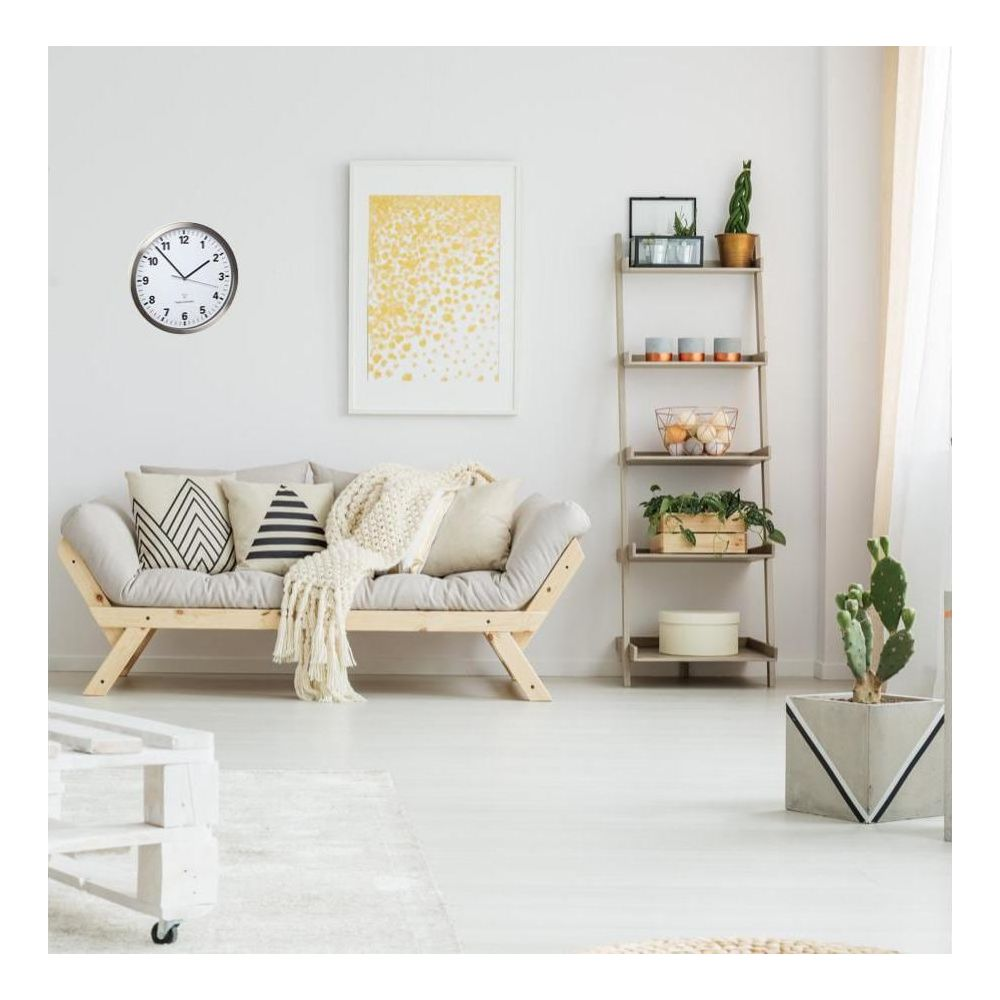 Ein helles Wohnzimmer mit Sofa, Leiterregal und Kaktus.