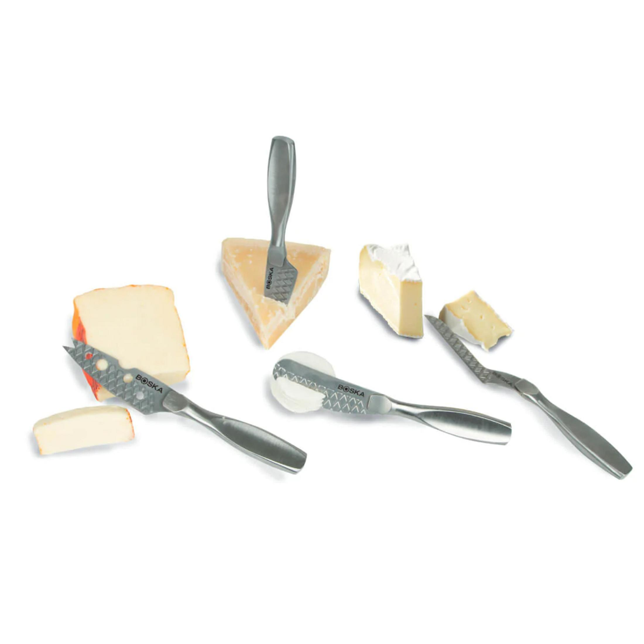 Cheese knife set with various cheeses on a white background.