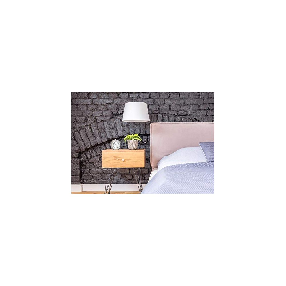 Ein Nachttisch aus Holz mit einem kleinen Blumentopf und einer Uhr neben einem Bett.