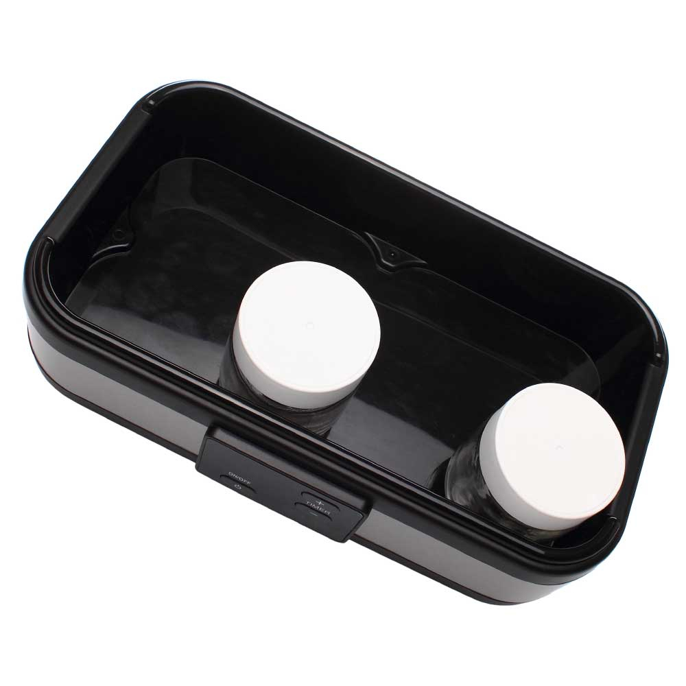 Ein schwarzes Rechteck mit zwei Gläsern mit weißen Deckeln darin.