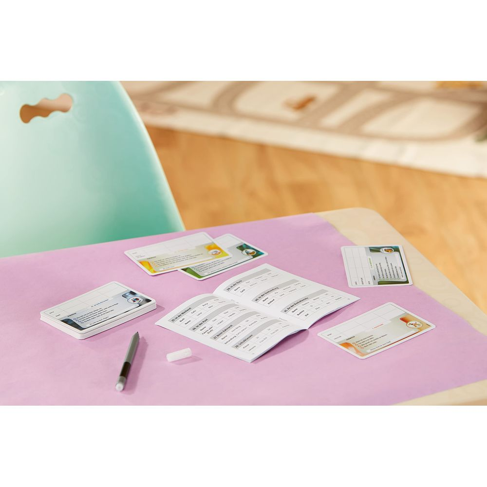 Ein Schreibtisch mit Karten, einem Buch und Stiften, alles auf einem lila Papier.