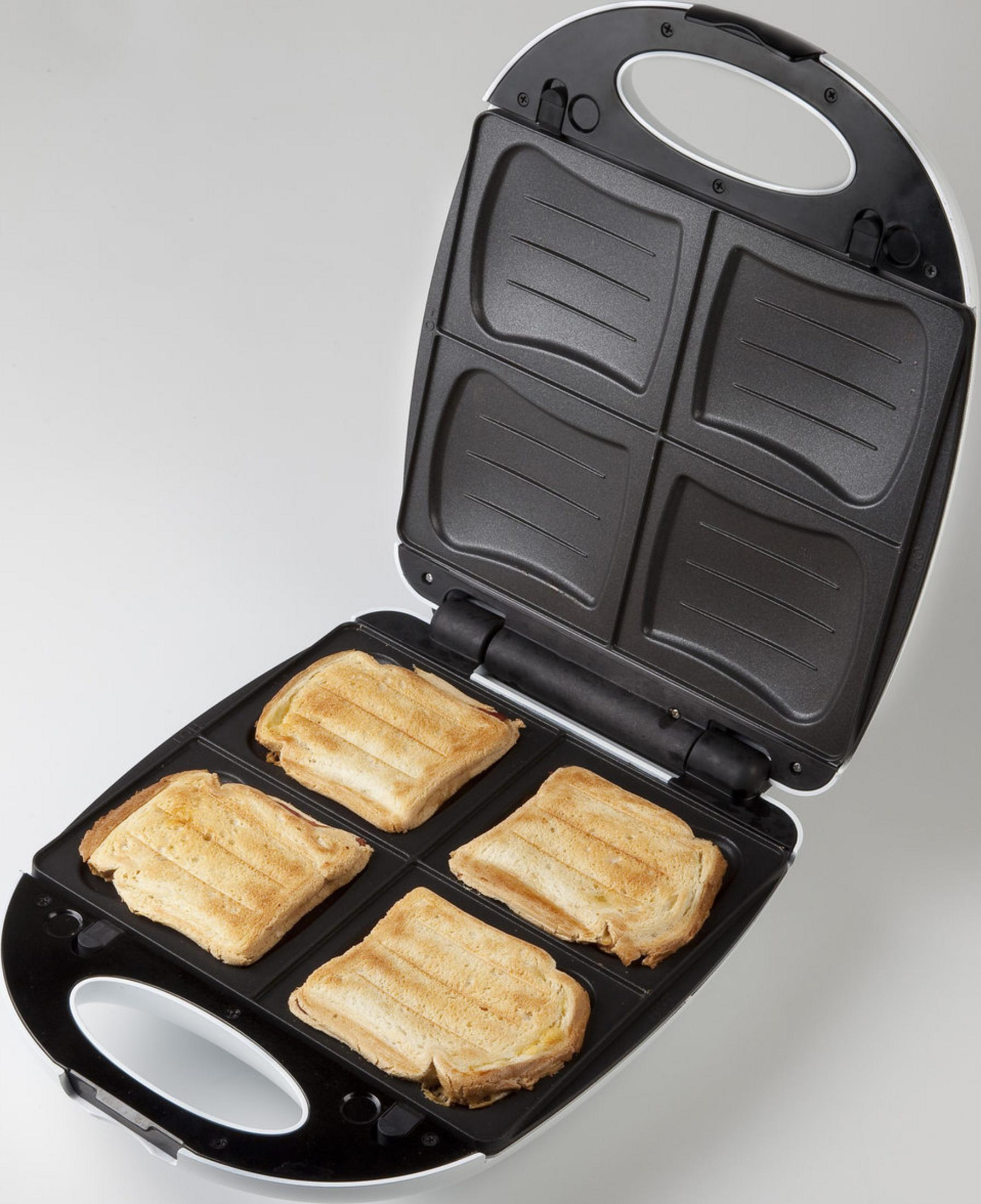 Otwarty opiekacz do kanapek z czterema złocistobrązowymi kanapkami.