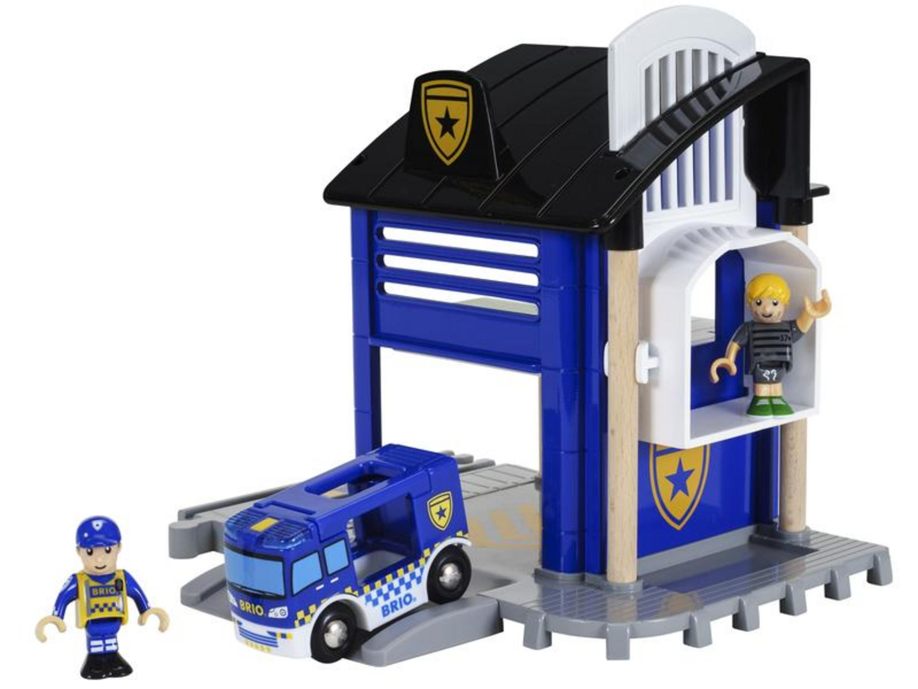 Zabawkowa remiza strażacka z ciężarówką i dwiema figurkami.