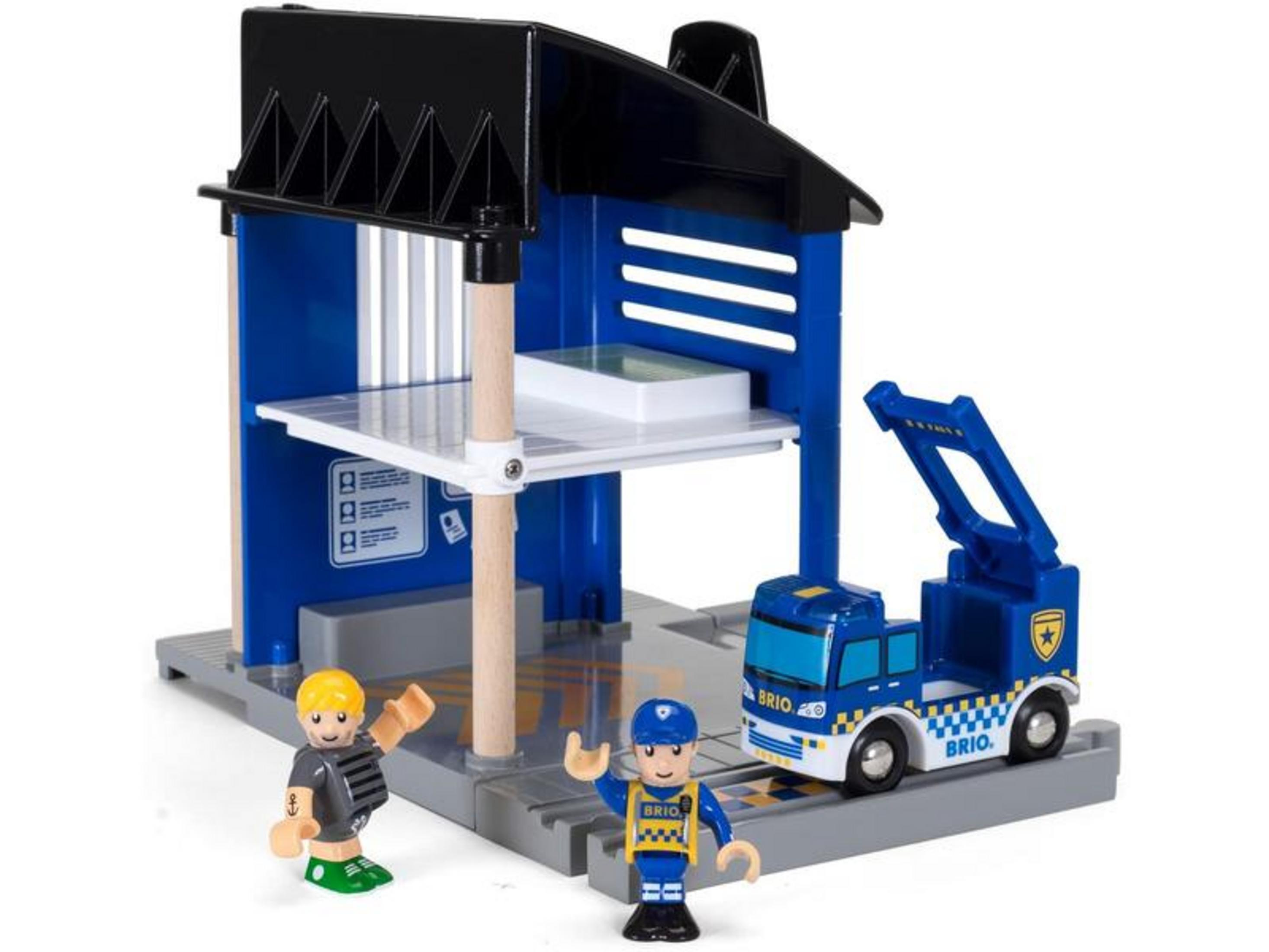 Policyjna ciężarówka Brio z dźwigiem obok posterunku policji z dwiema postaciami.