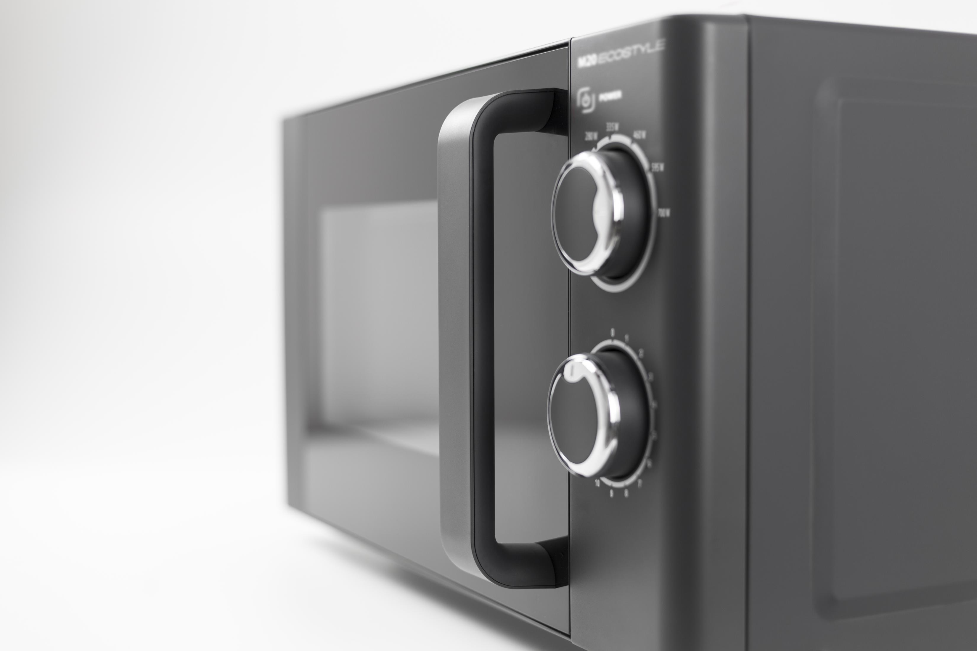 Forno a microonde grigio con manopole e maniglia argentate, su sfondo bianco.