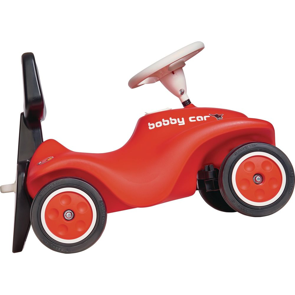 Czerwony jeździk z białym kółkiem i czarnym uchwytem z tyłu.