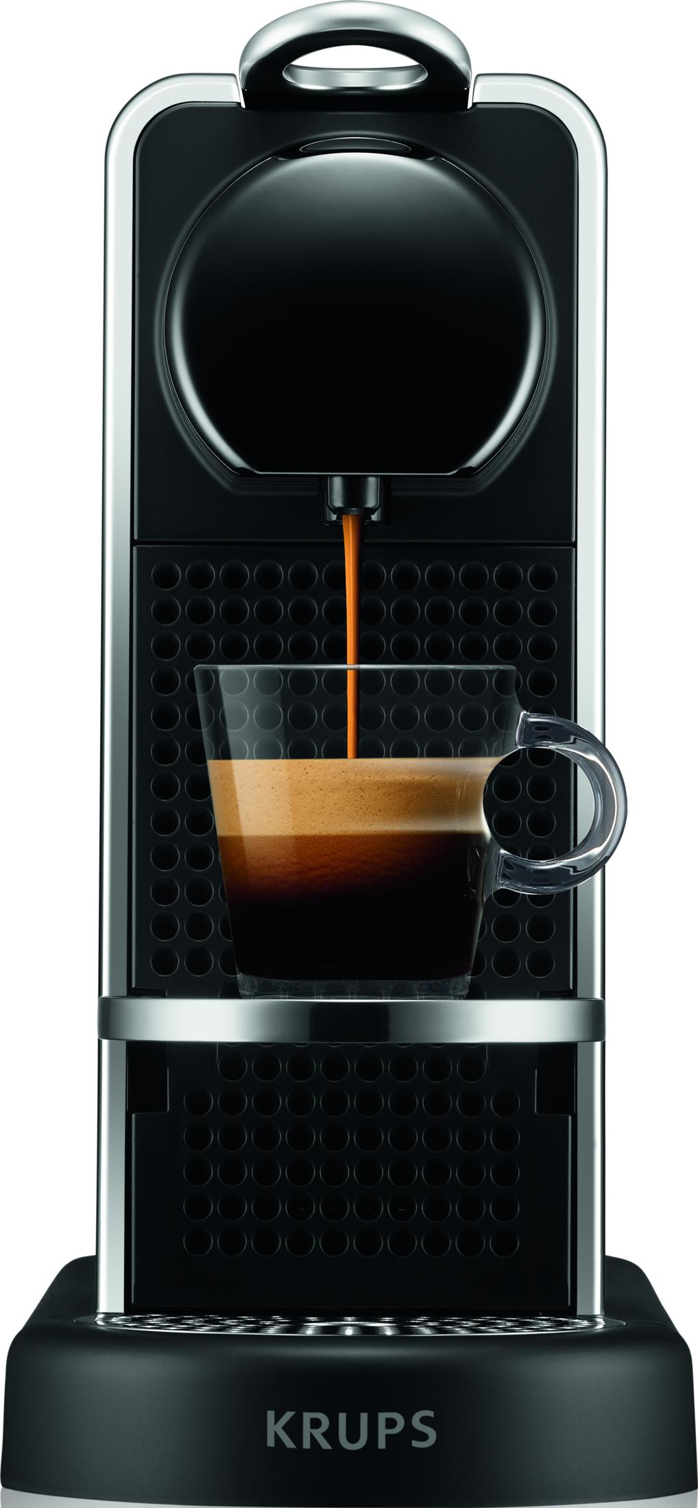 Eine Kaffeemaschine brüht Espresso in eine Glas Tasse mit Schaum.