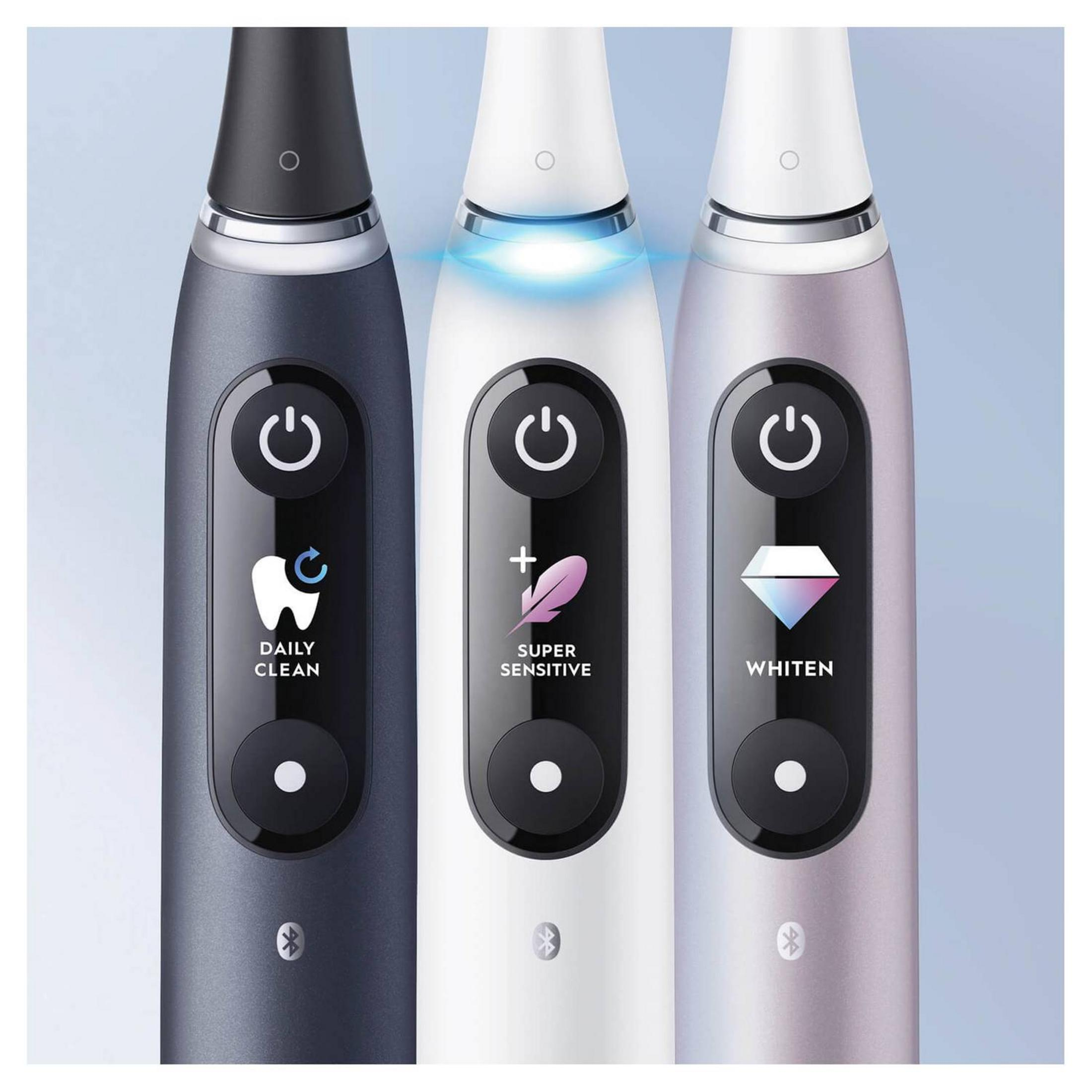 Trzy szczoteczki elektryczne w kolorze ciemnoszarym, białym i różowego złota z podświetlanymi przyciskami.