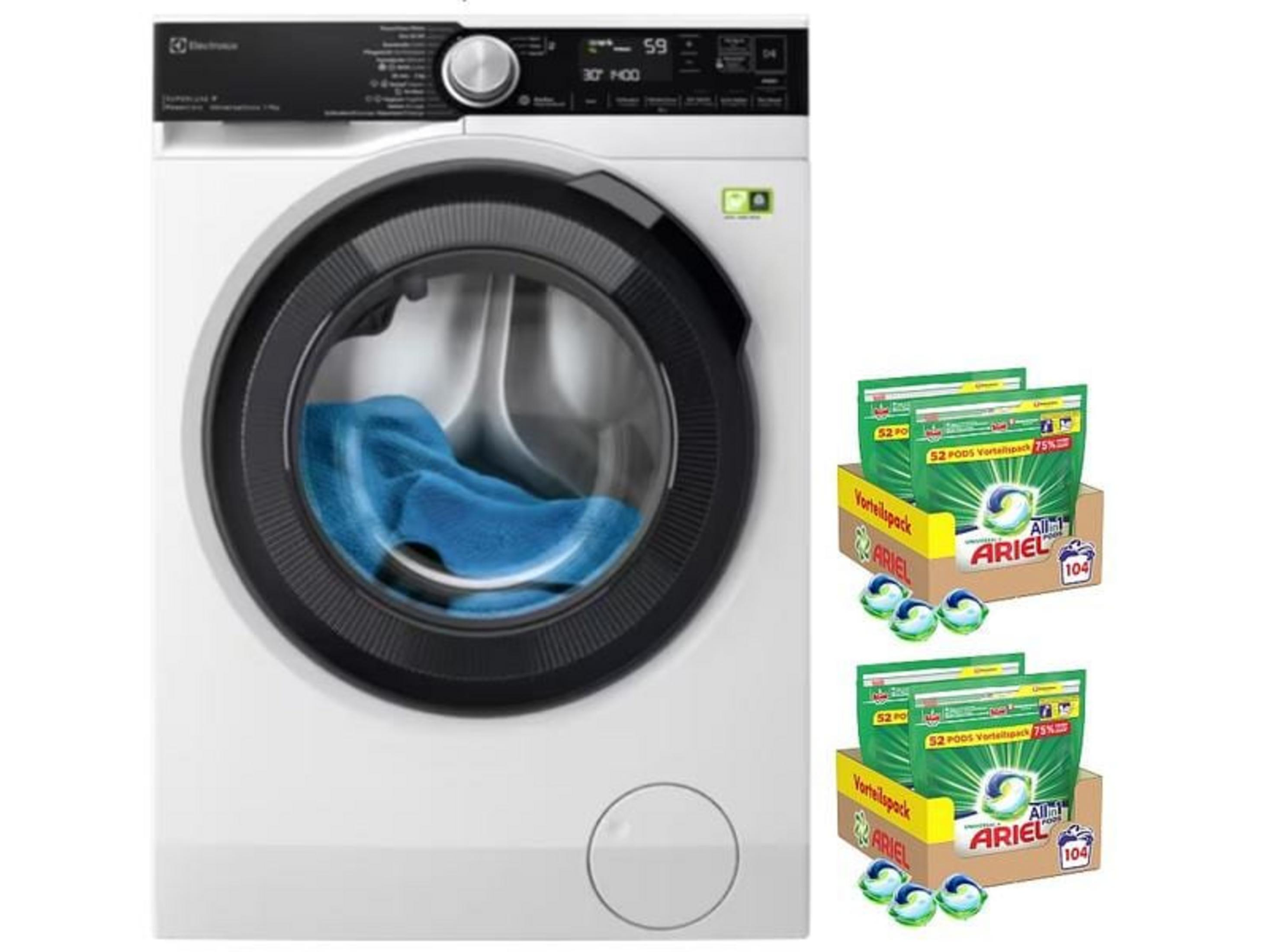 Machine à laver blanche avec linge bleu, à côté des paquets de capsules Ariel.