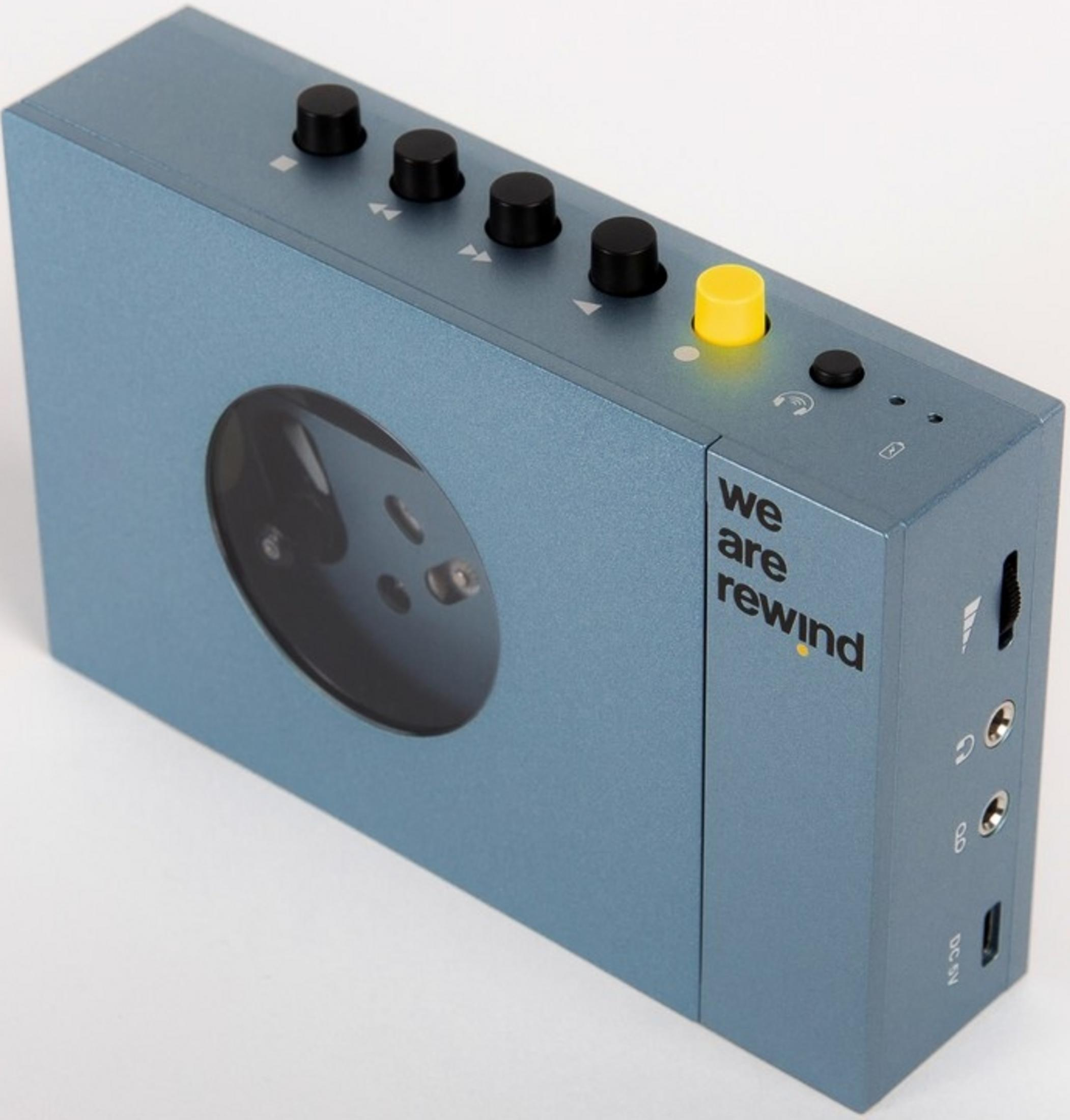 Un lecteur de cassettes bleu avec des boutons noirs et un bouton jaune.