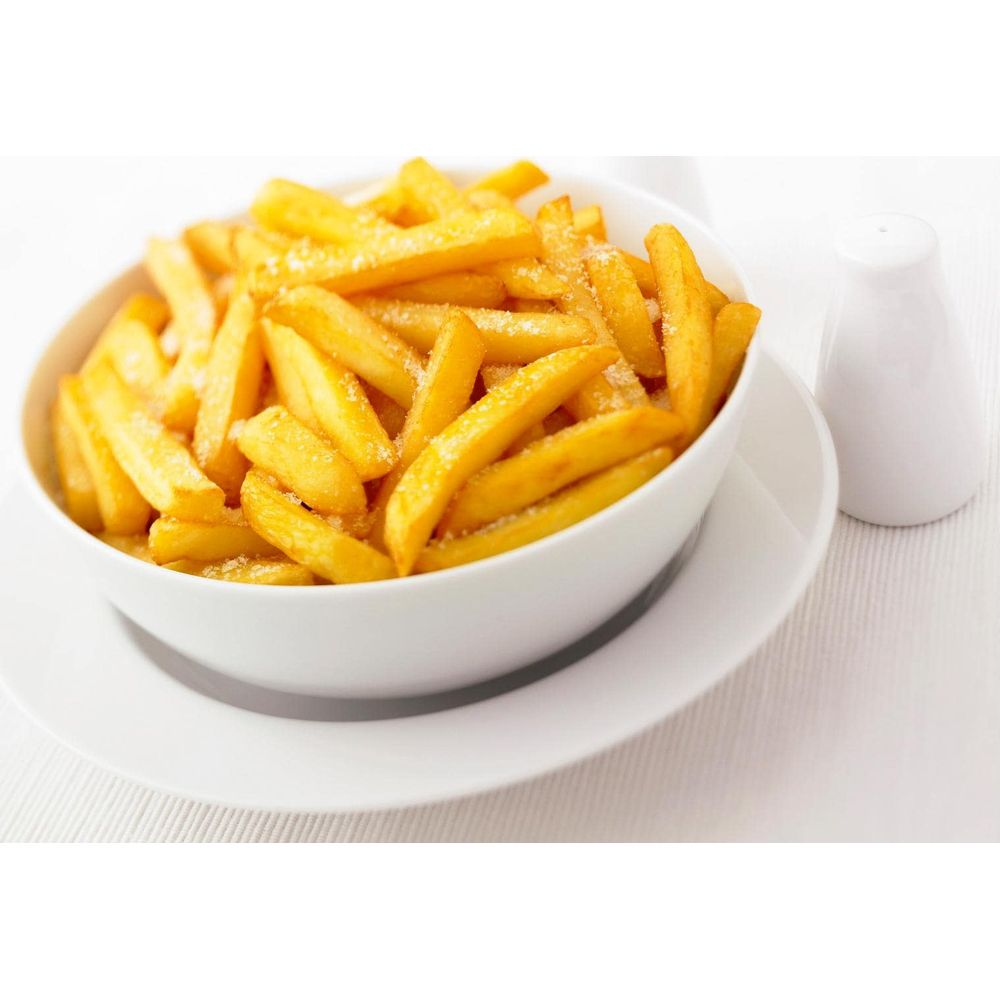 Biała miska pełna złotobrązowych frytek, posypanych solą.