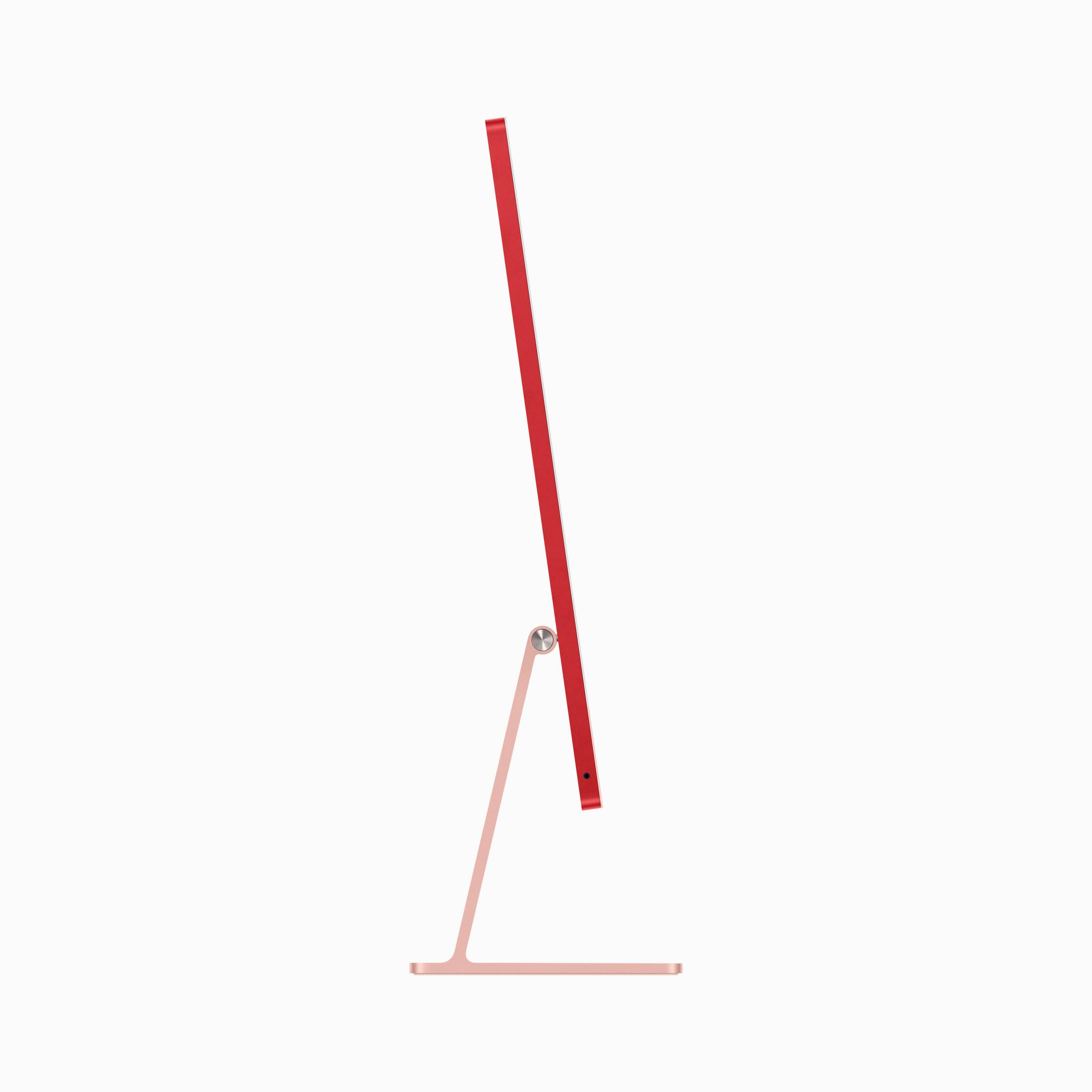 Czerwony iMac z srebrną podstawą widziany z boku na białym tle.