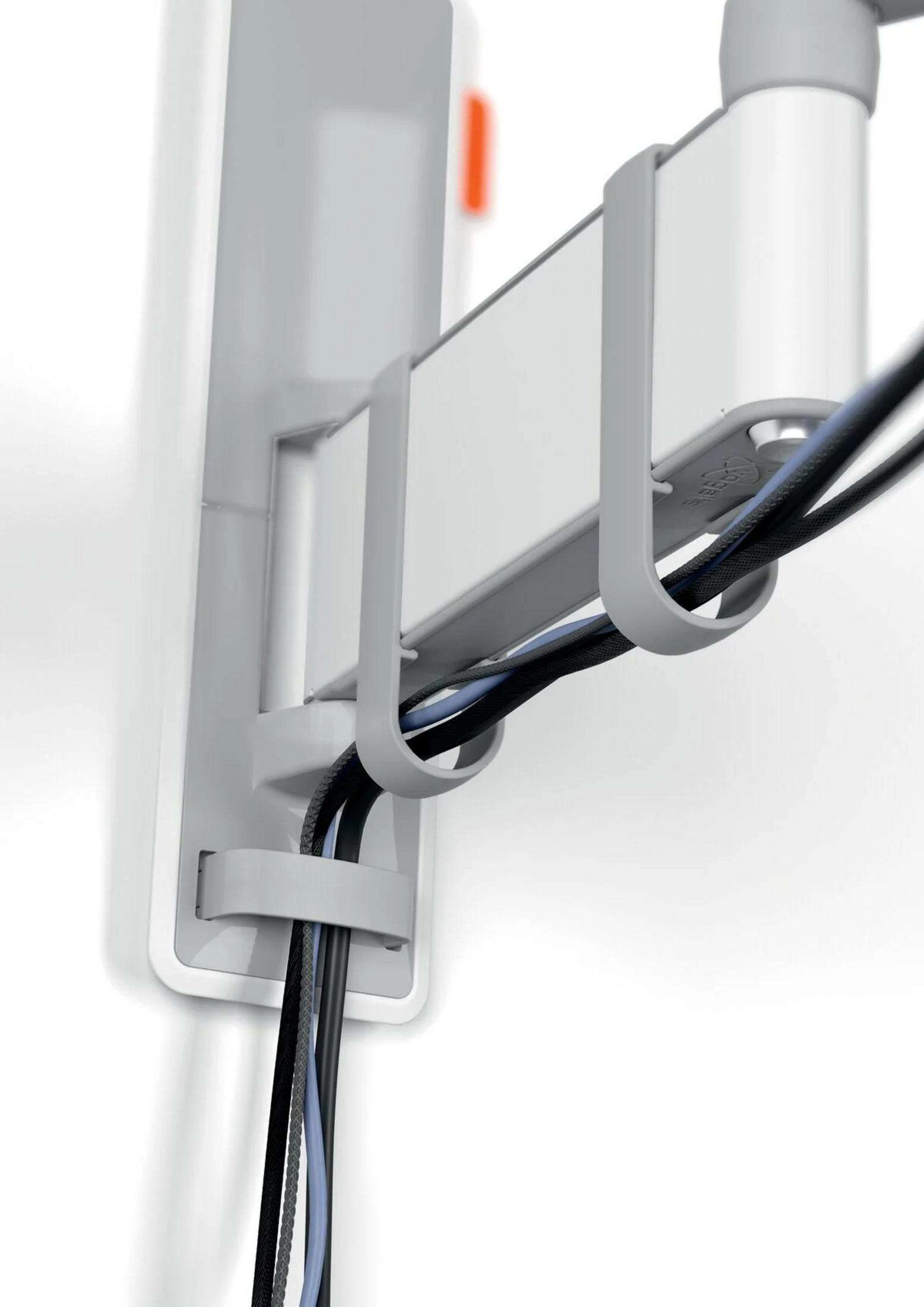 Szary uchwyt na kable z czarnymi i niebieskimi przewodami.