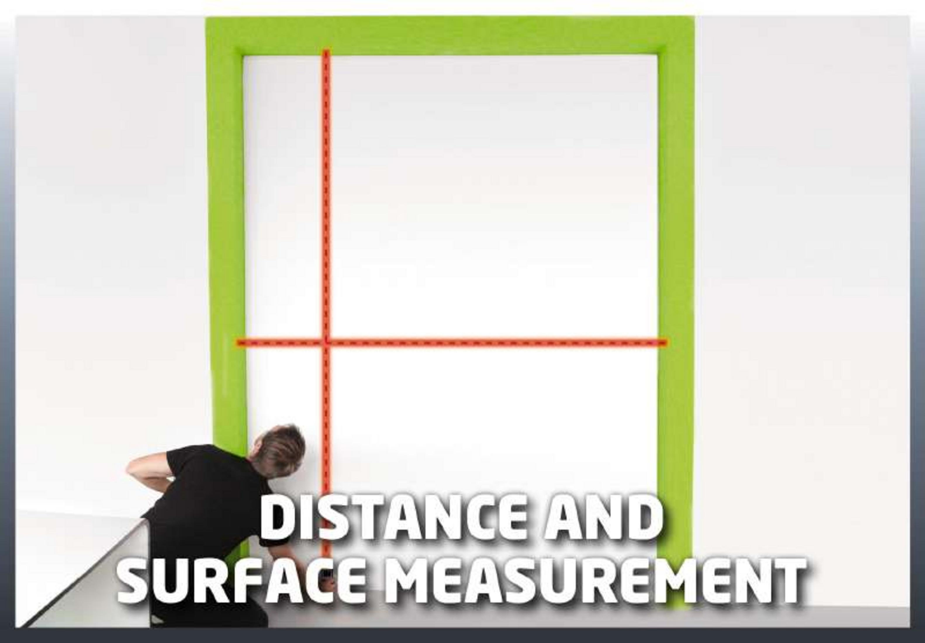 Mężczyzna mierzy powierzchnię taśmą mierniczą na tle białej ściany z zieloną ramką.