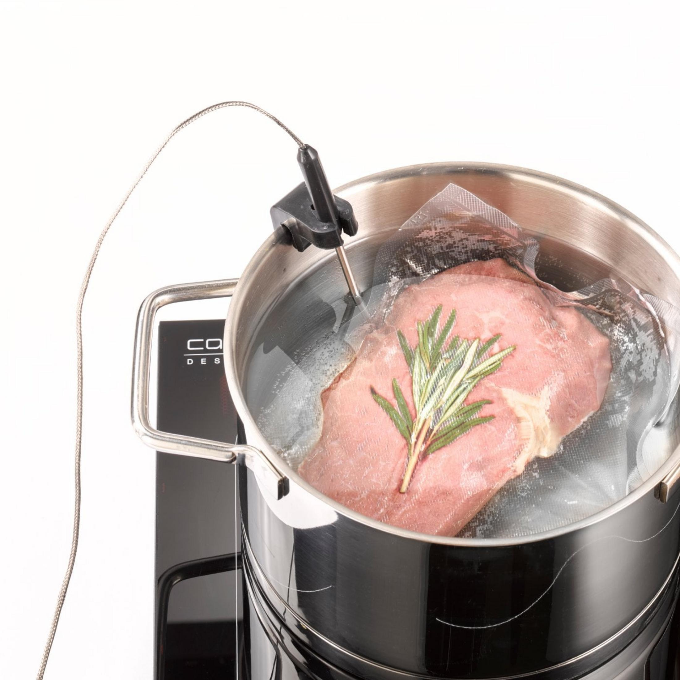 Carne in busta con rosmarino in pentola con acqua e termometro.
