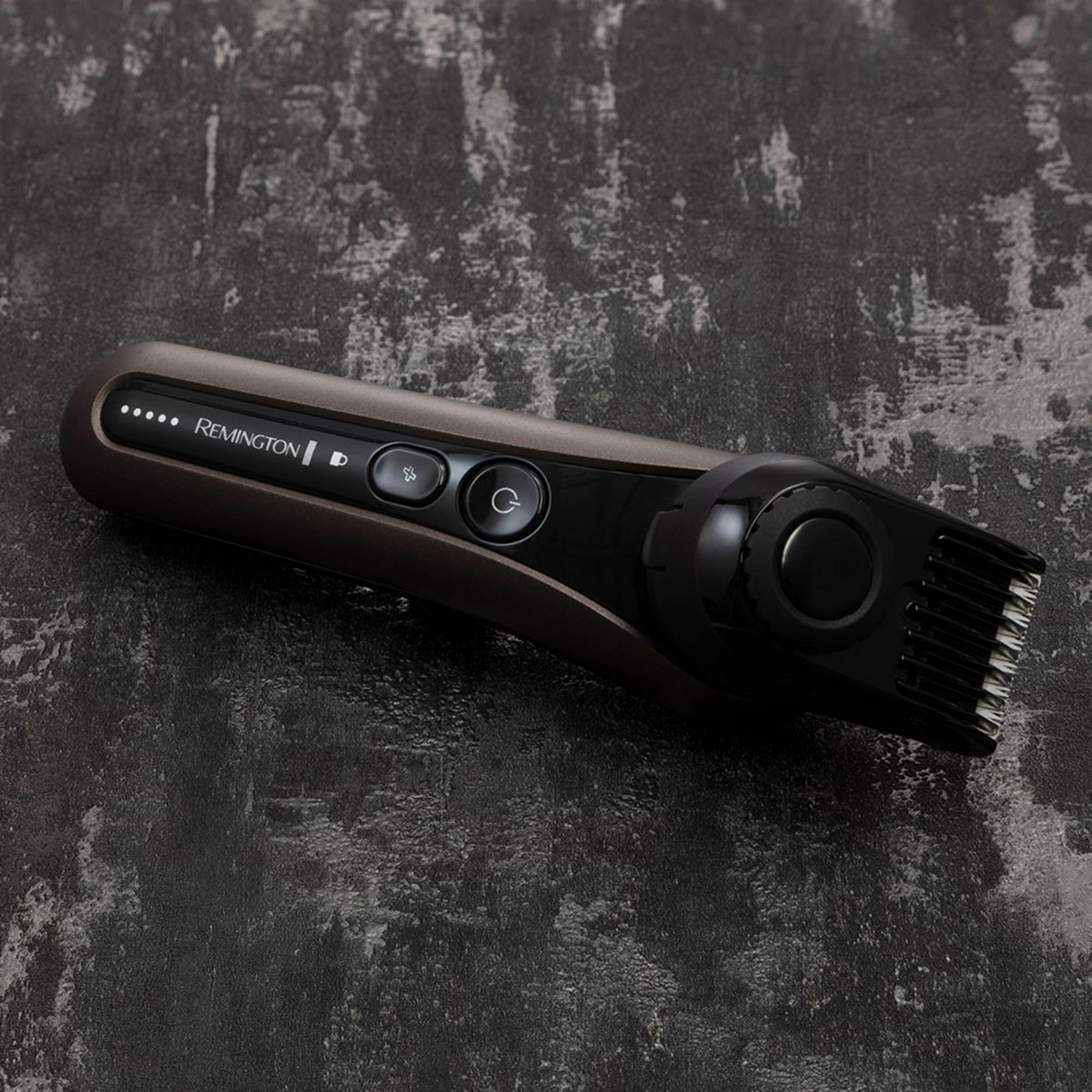 Ein dunkler Remington Trimmer mit Bedienelementen und Klingen auf dunklem Grund.