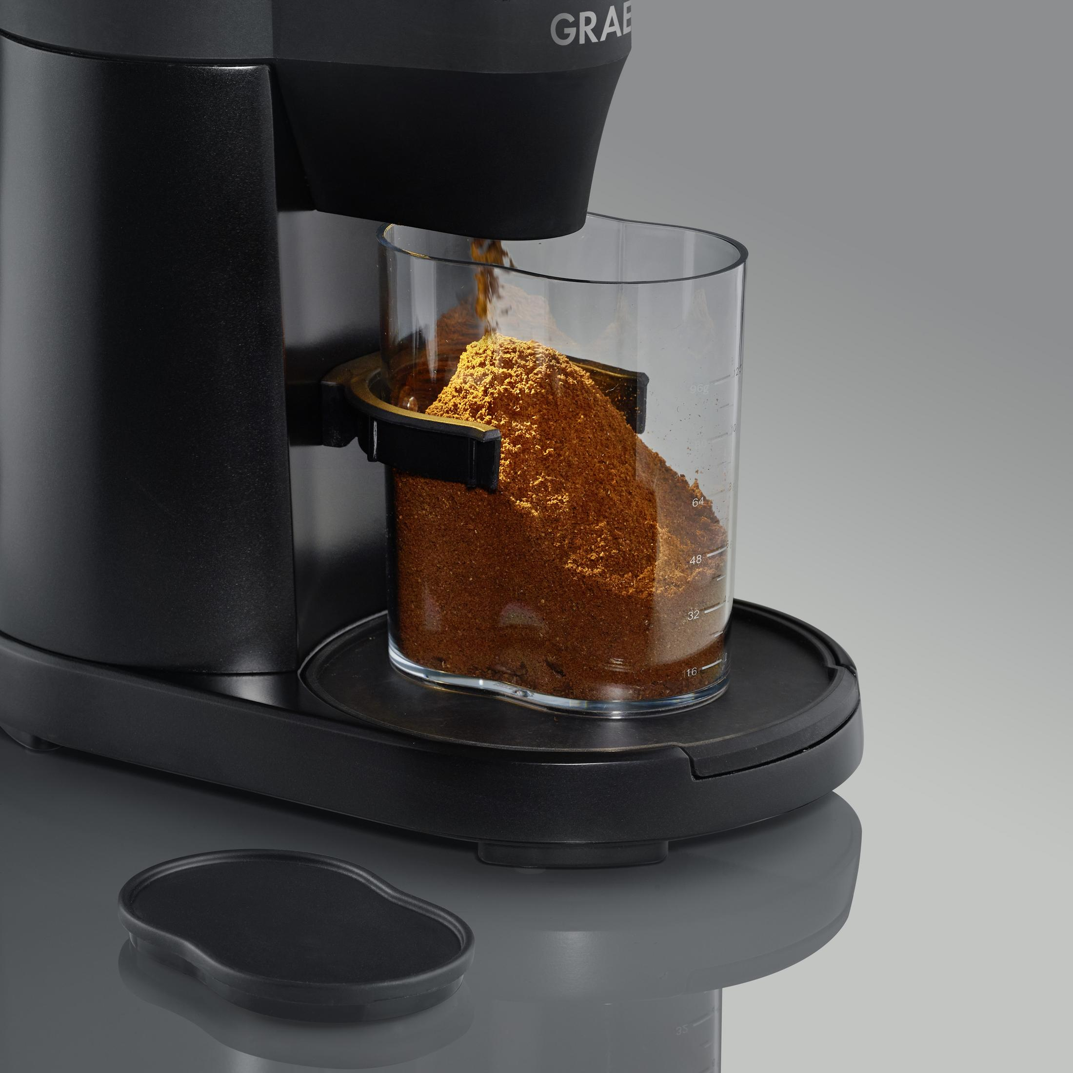 Il caffè macinato viene macinato in un contenitore trasparente.