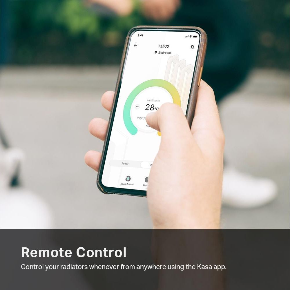 Une main tient un téléphone affichant une application de chauffage à 28°C.