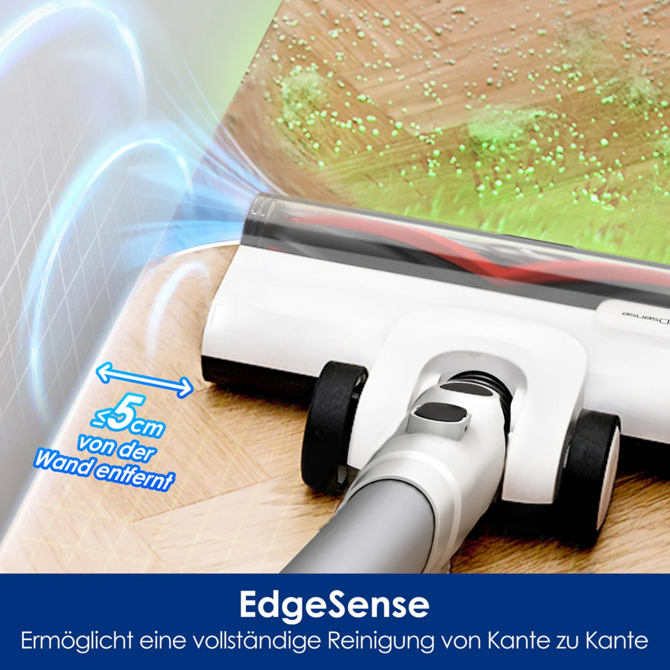 Biały odkurzacz czyści kurz na drewnianej podłodze, 5cm od ściany.