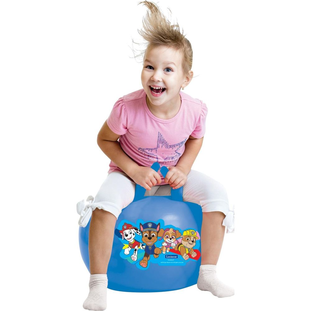 Una niña feliz monta una pelota azul con personajes de Paw Patrol.