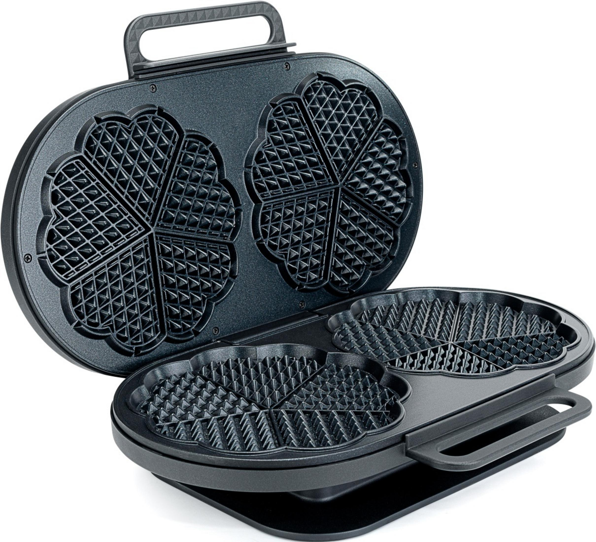 Una piastra per waffle nera aperta con forme a cuore e manico.