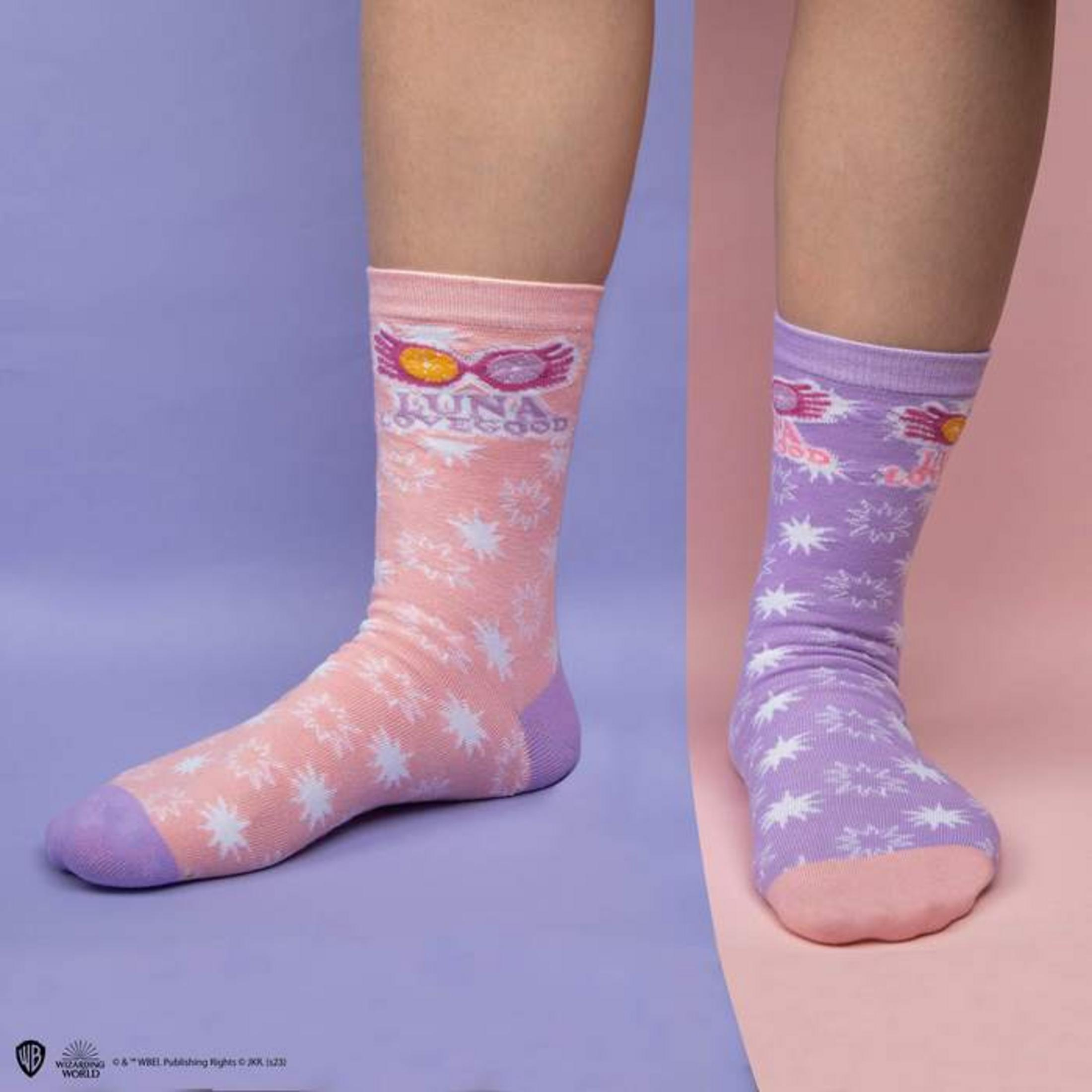 Dos pies con calcetines que muestran gafas de Luna Lovegood y estrellas.
