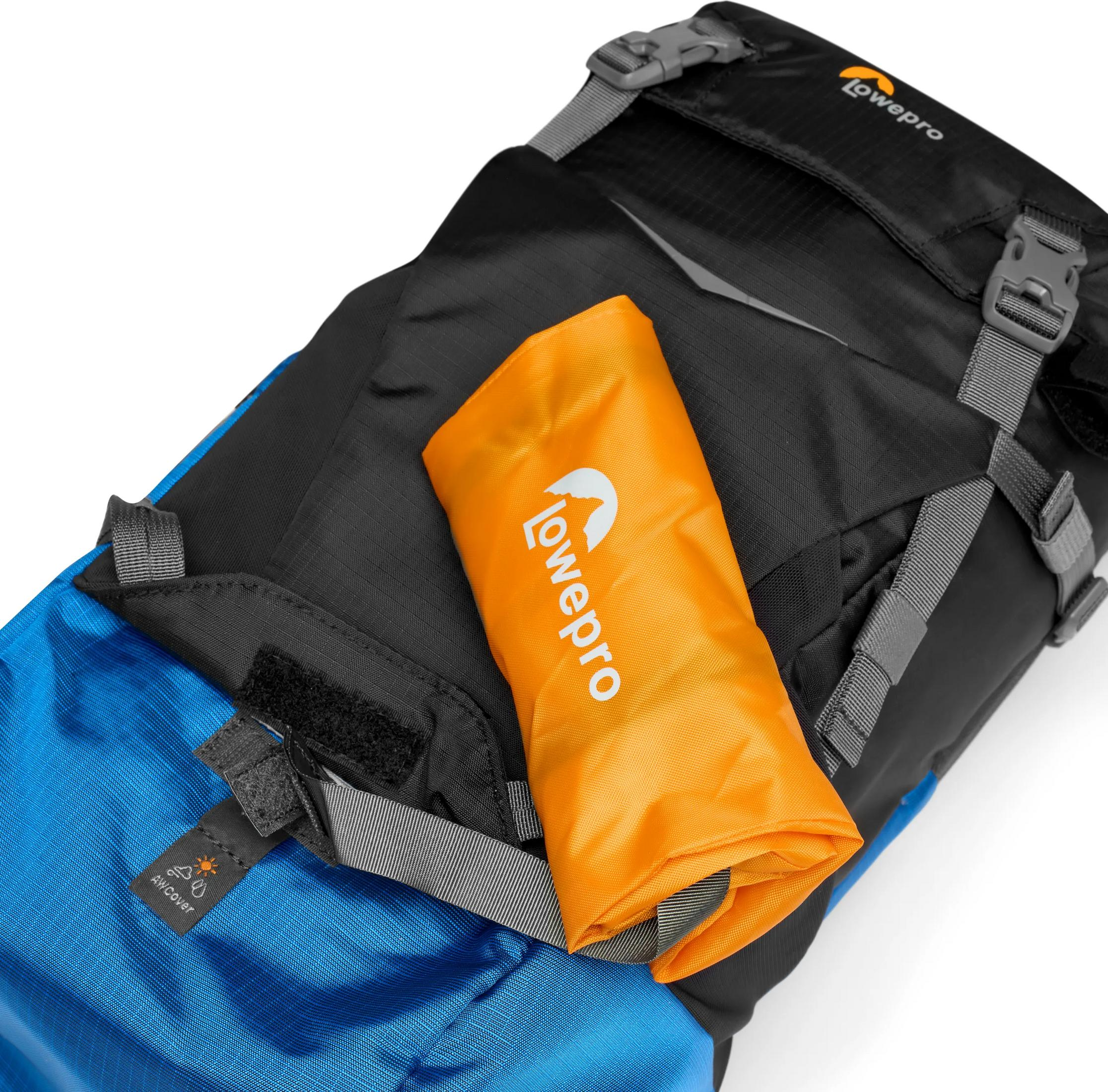 Un sac à dos bleu et noir avec une housse orange pliée dessus.
