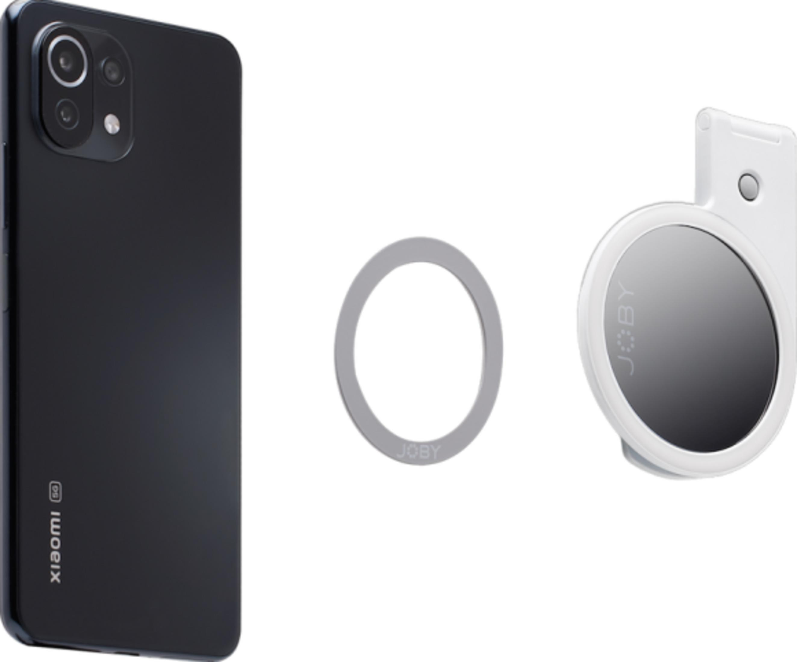 Ein schwarzes Smartphone, ein silberner Ring und ein weißer Spiegel mit JO BY-Logo.