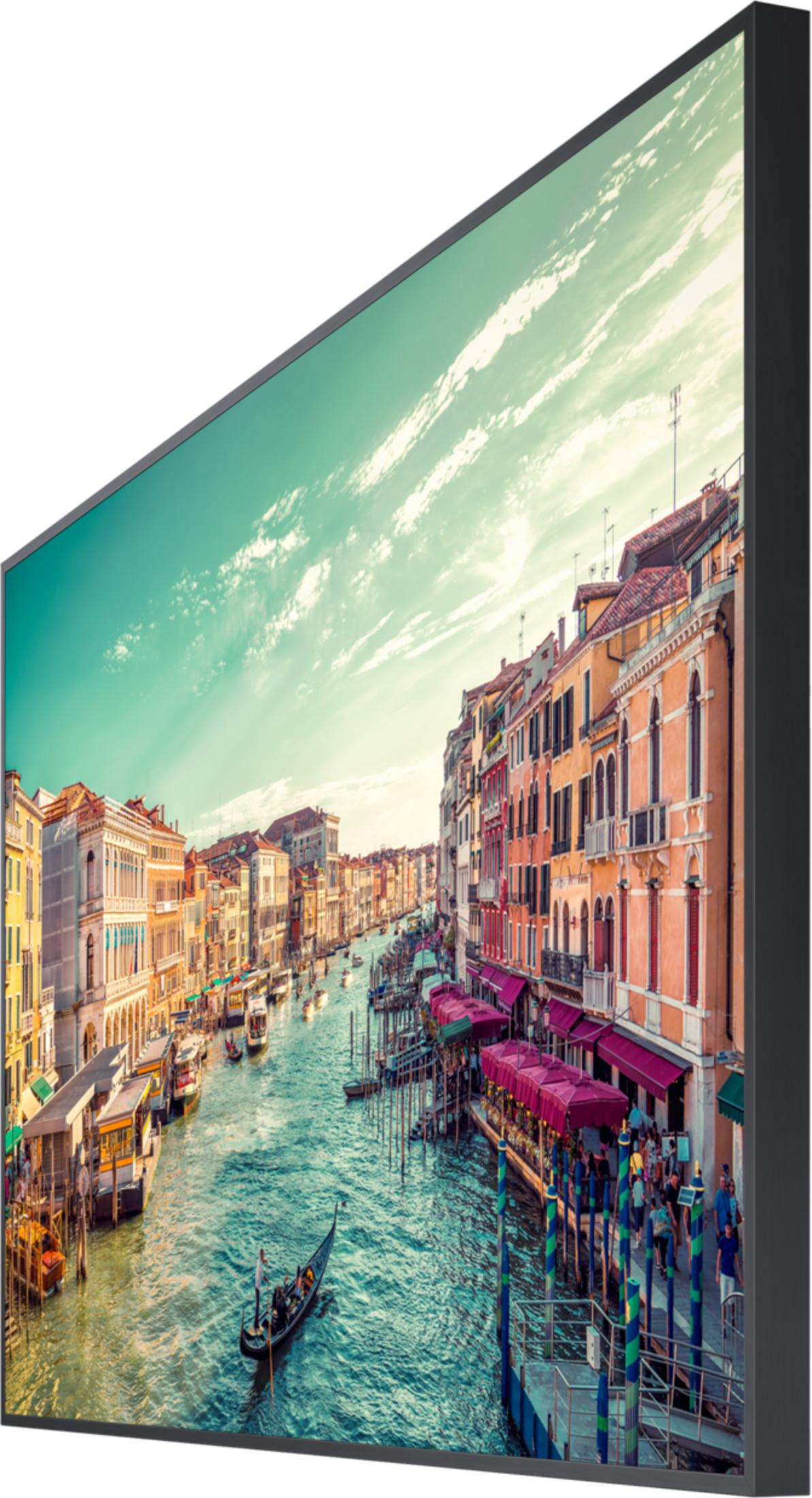 Un canale a Venezia con gondola, barche ed edifici colorati sotto un cielo blu.