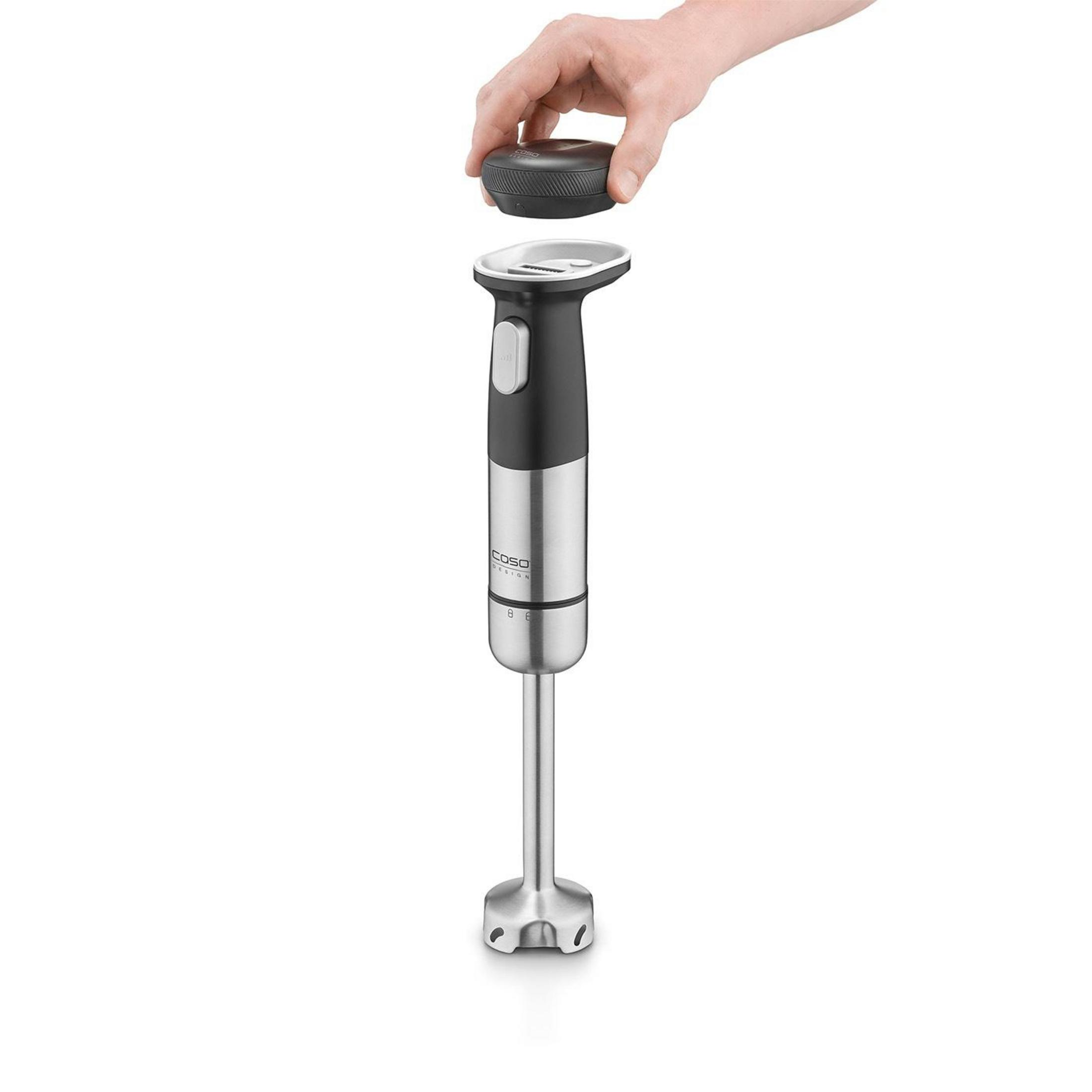 Una mano tiene un accessorio nero sopra un frullatore a immersione in acciaio inox.
