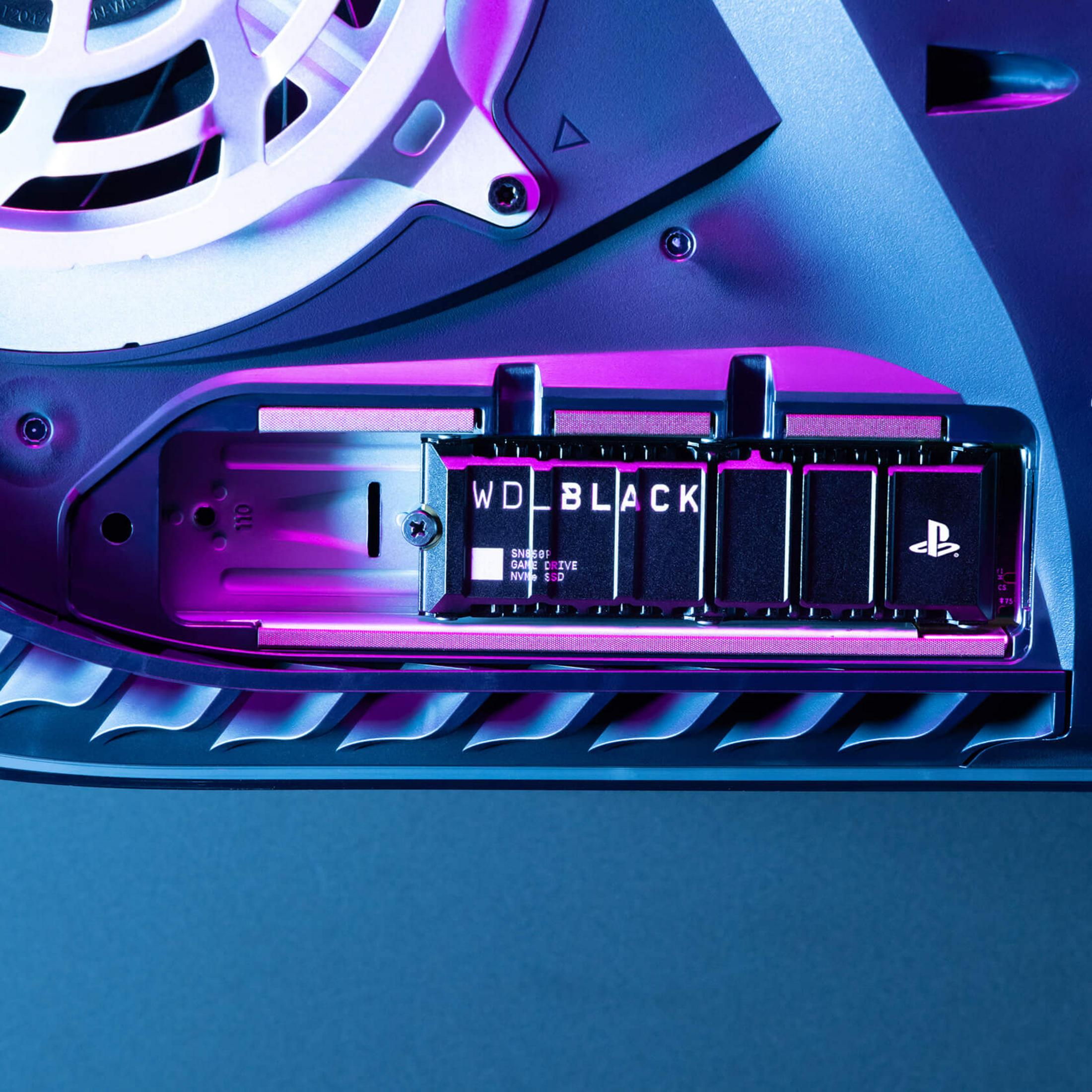 Dysk WD Black NVMe SSD w zatoce napędu PS5 z fioletowym podświetleniem.
