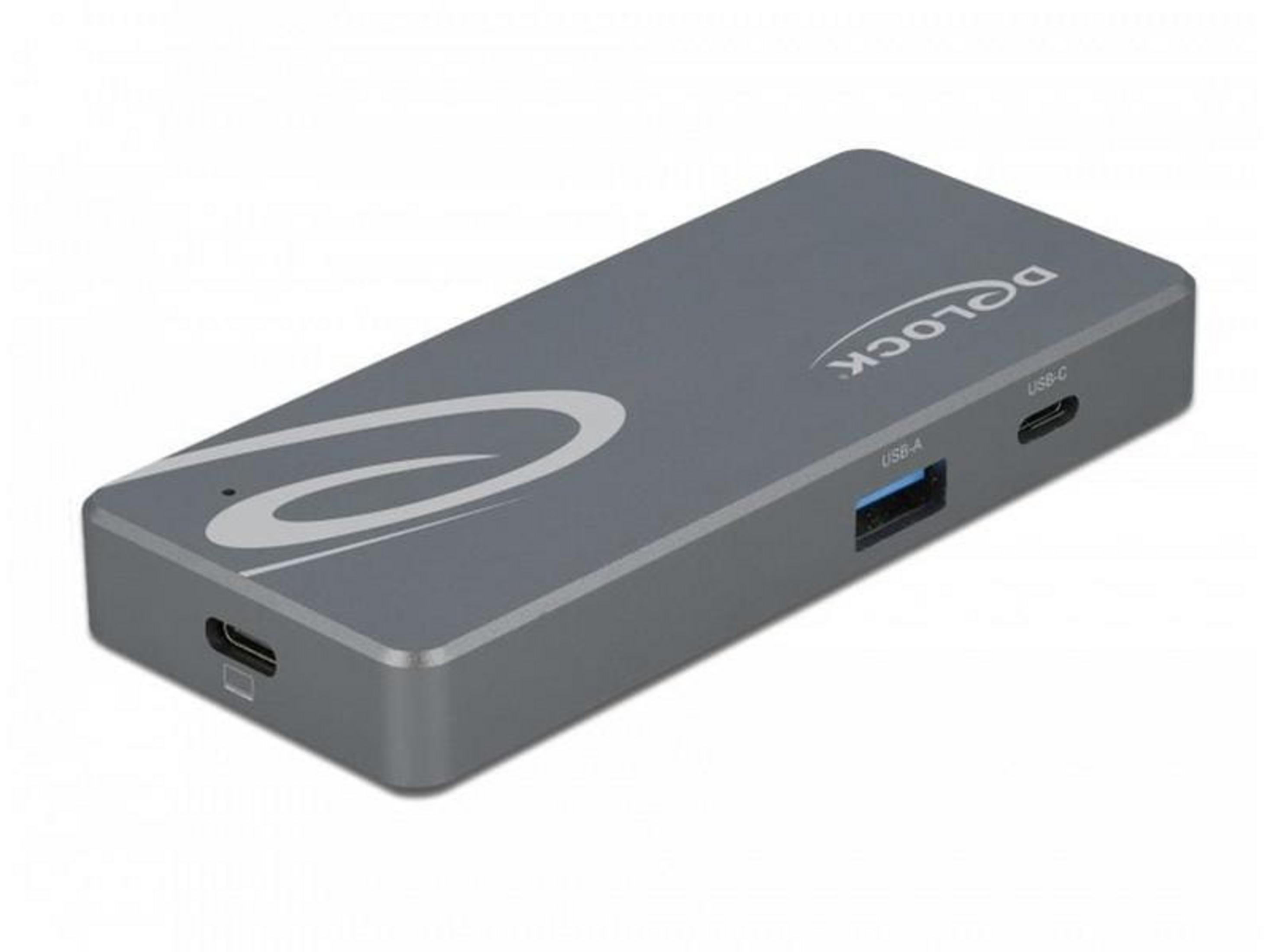 Hub USB-C gris con puerto USB-A, puerto USB-C e interruptor de encendido.