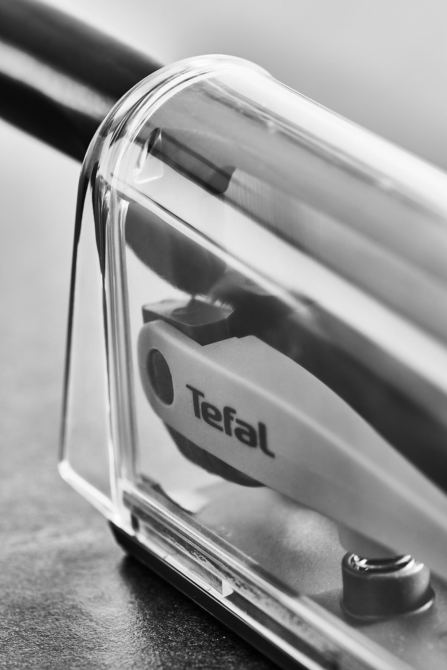 Gros plan d'un produit Tefal avec un boîtier transparent et une poignée en métal.