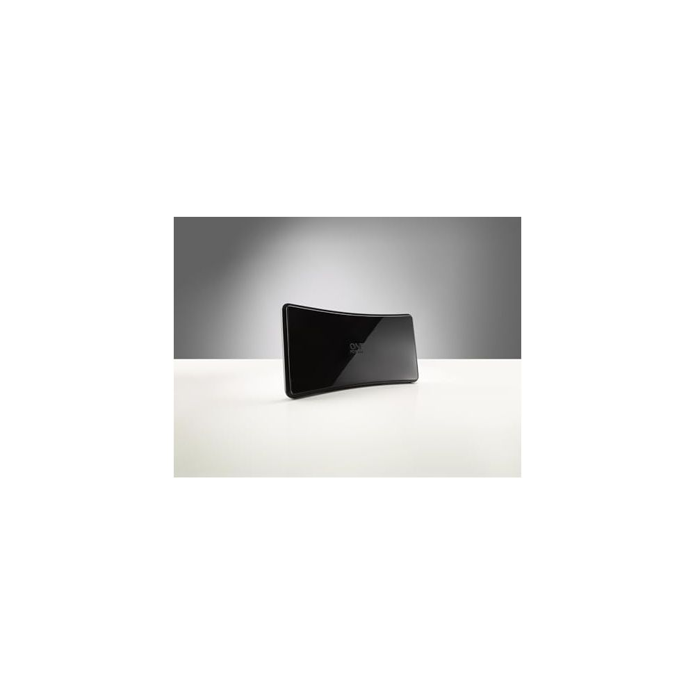 Un appareil noir et incurvé avec le logo "ONE" est posé sur une table blanche.