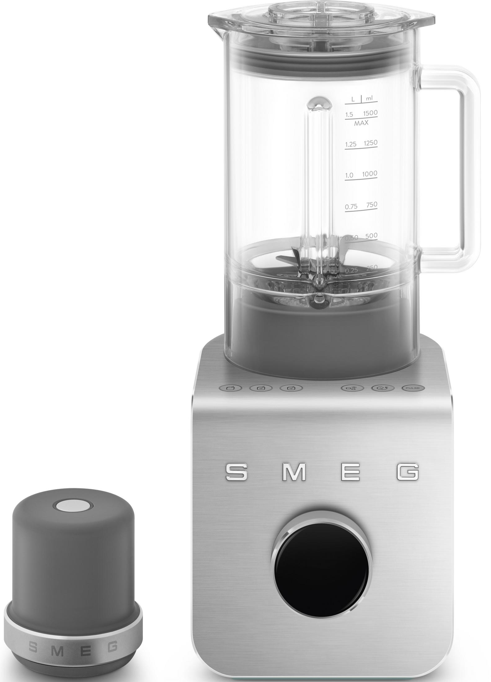 Srebrny blender Smeg ze szklanym dzbankiem i osobną szarą pokrywką.