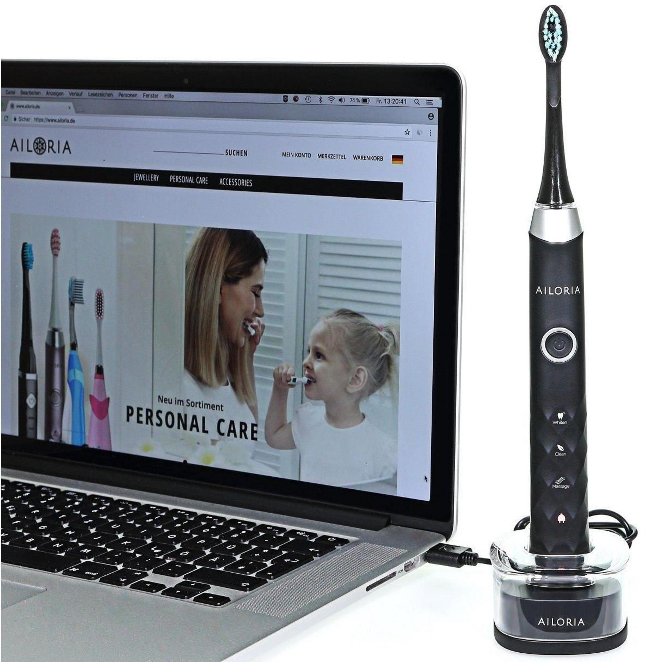 Ein Laptop zeigt die Website von AILORIA mit Zahnbürsten. Daneben steht eine elektrische Zahnbürste.