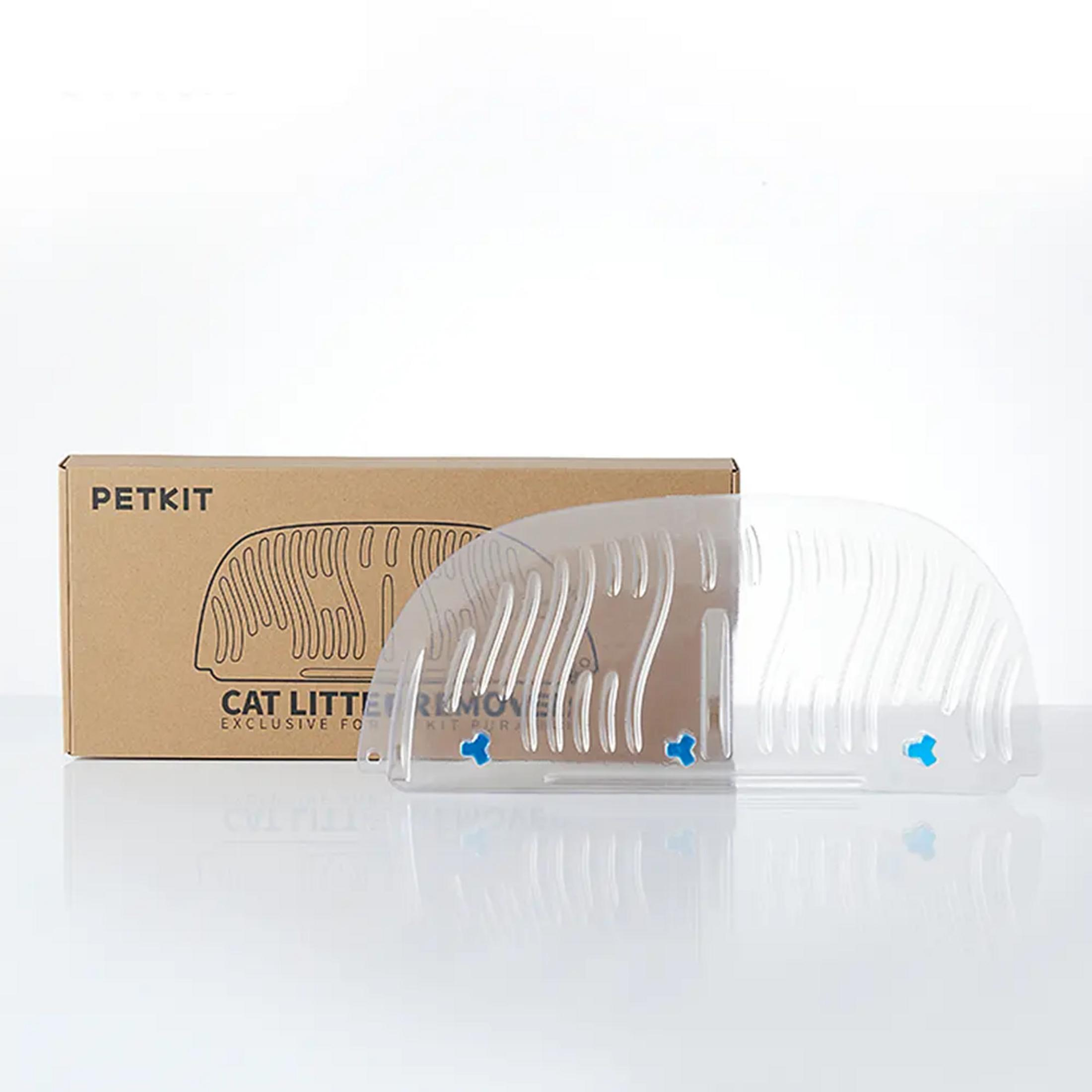 Un setaccio trasparente per lettiera per gatti con chiusure blu accanto a una scatola di cartone marrone.