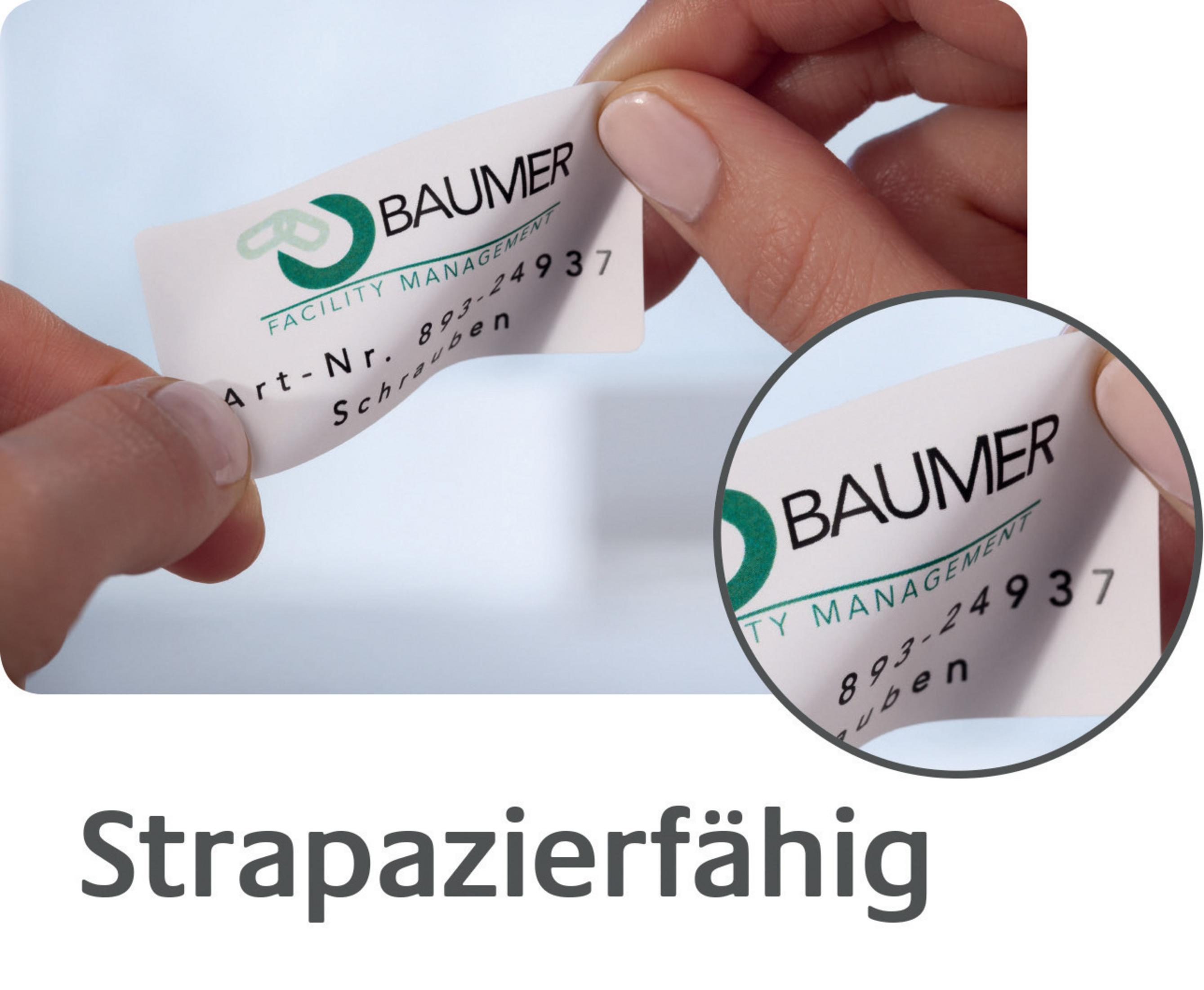 Eine Person hält ein Etikett mit dem Logo von Baumer und der Aufschrift "Strapazierfähig".