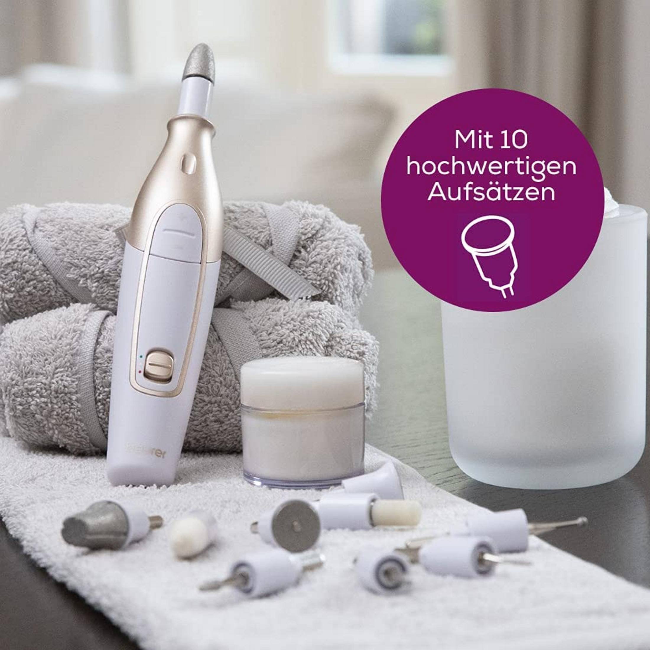 Een manicure set met wit handstuk, opzetstukken, crème en handdoeken.