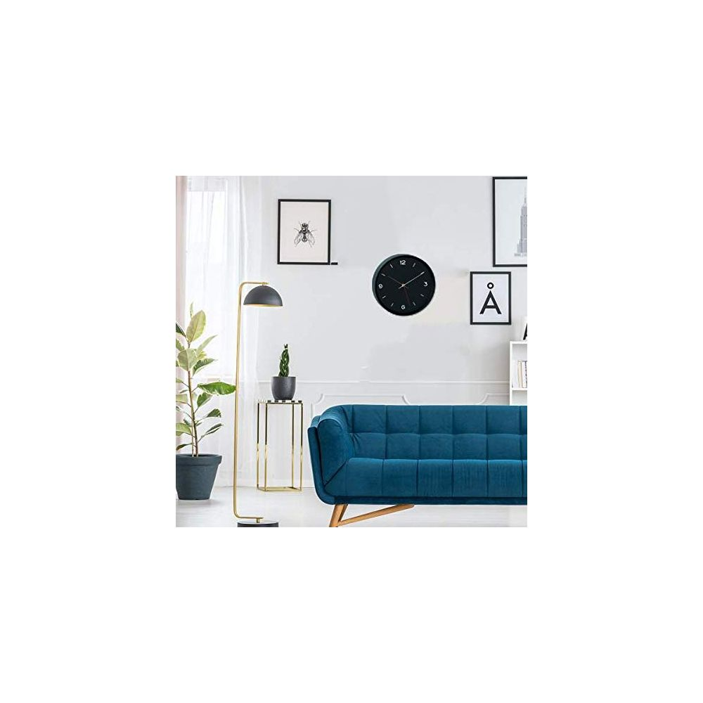 Ein blauer Sofa, ein Bodenlampen und Bilder an der Wand.
