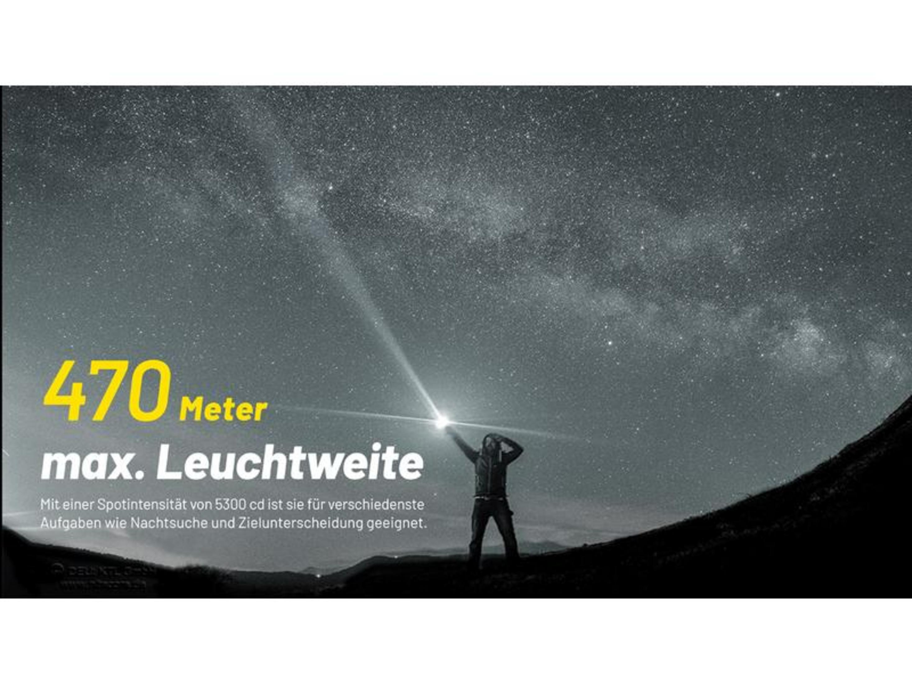 Mężczyzna oświetla gwieździste niebo latarką; zasięg 470m.