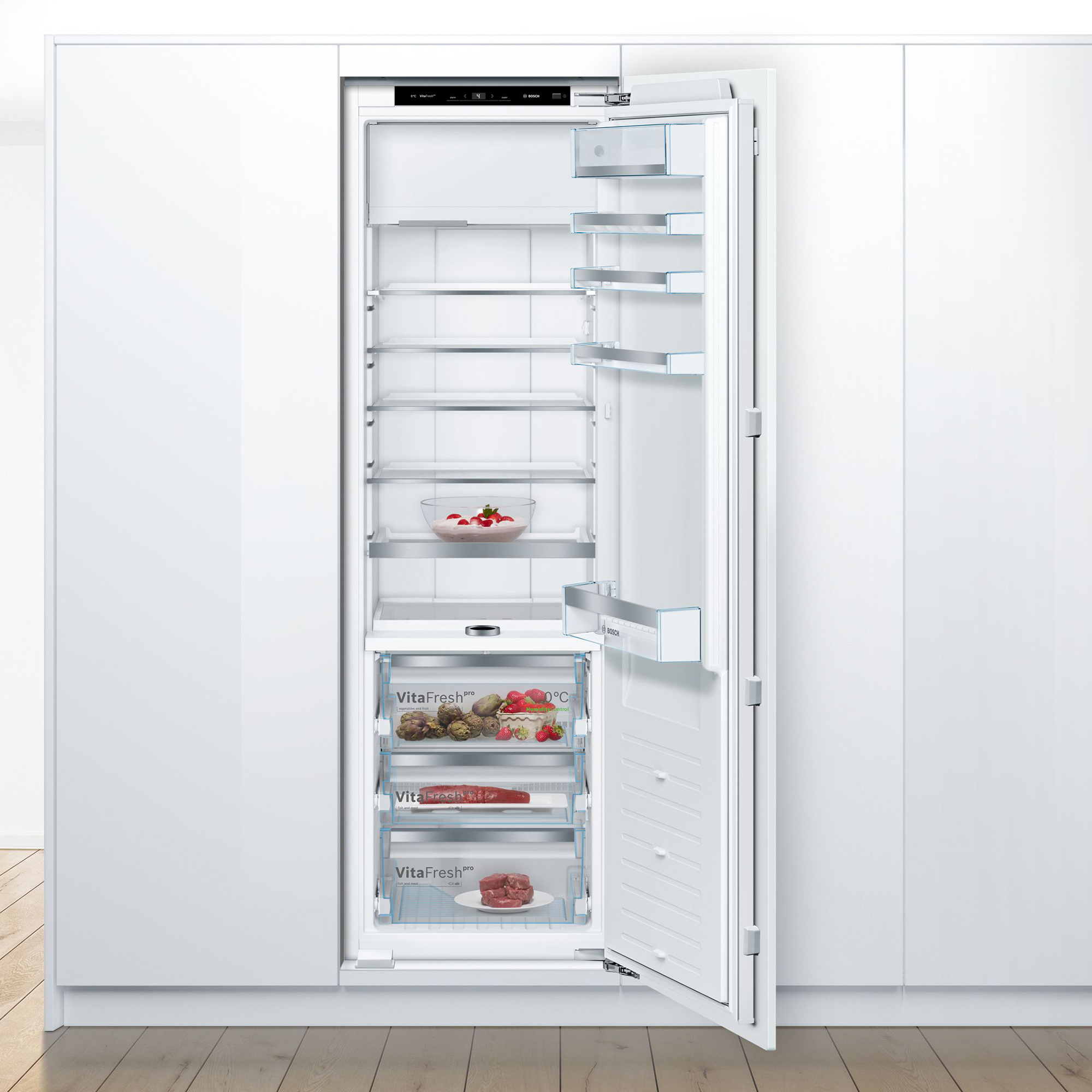 Un frigorifero bianco aperto con ripiani in vetro e cassetti. Contiene frutta, verdura e carne.
