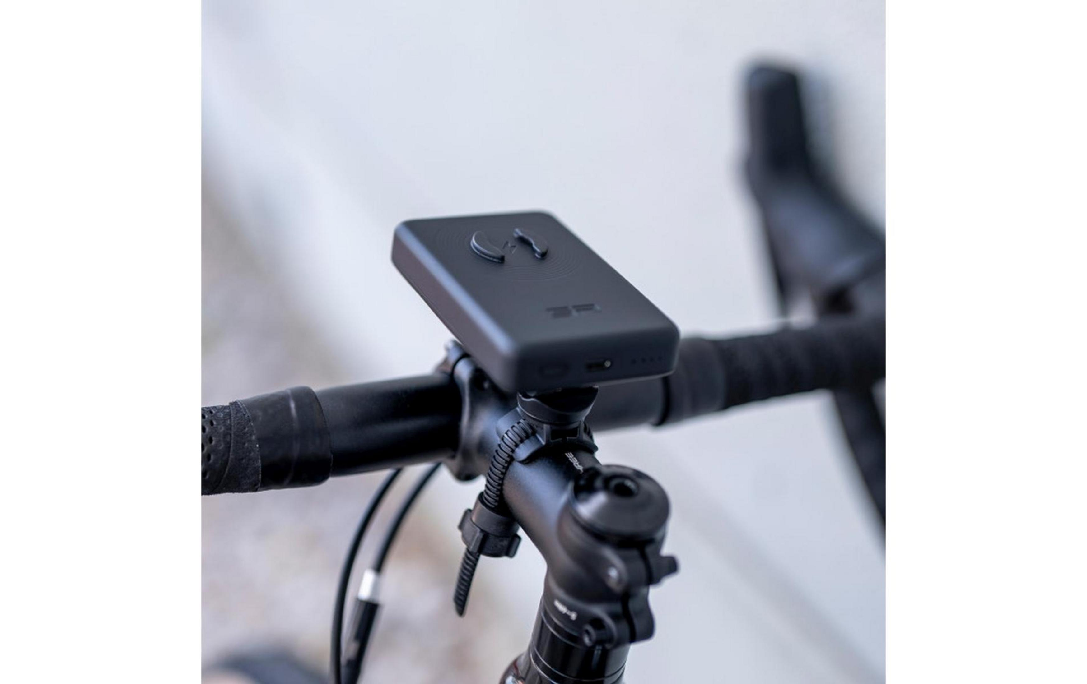 Un dispositivo nero con pulsanti è montato sul manubrio di una bicicletta.