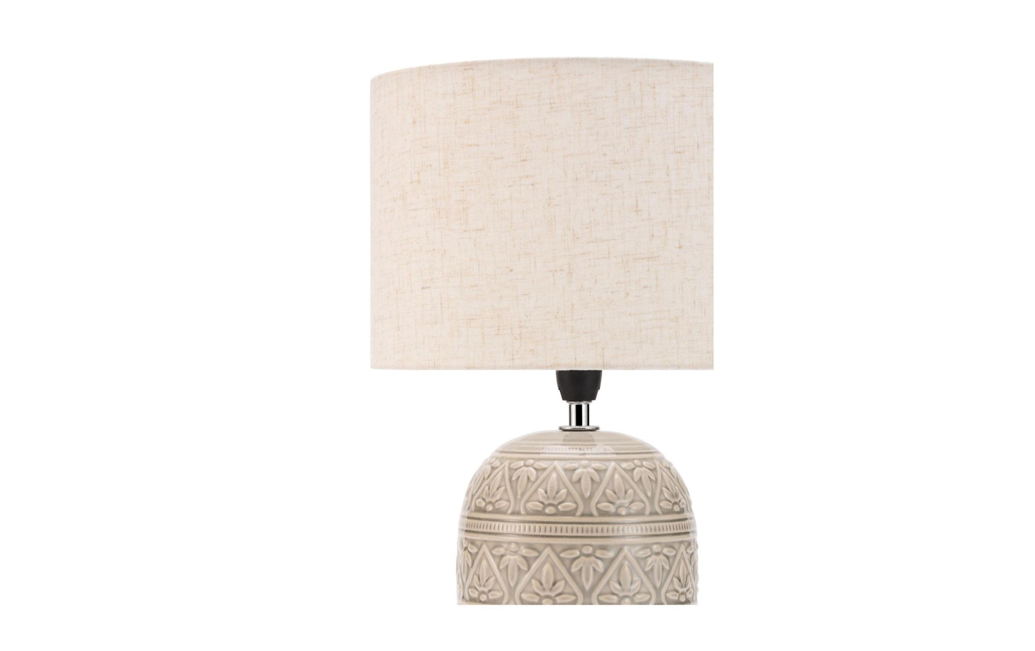 Szara lampa z jasno beżowym materiałowym kloszem i wzorzystą podstawą.