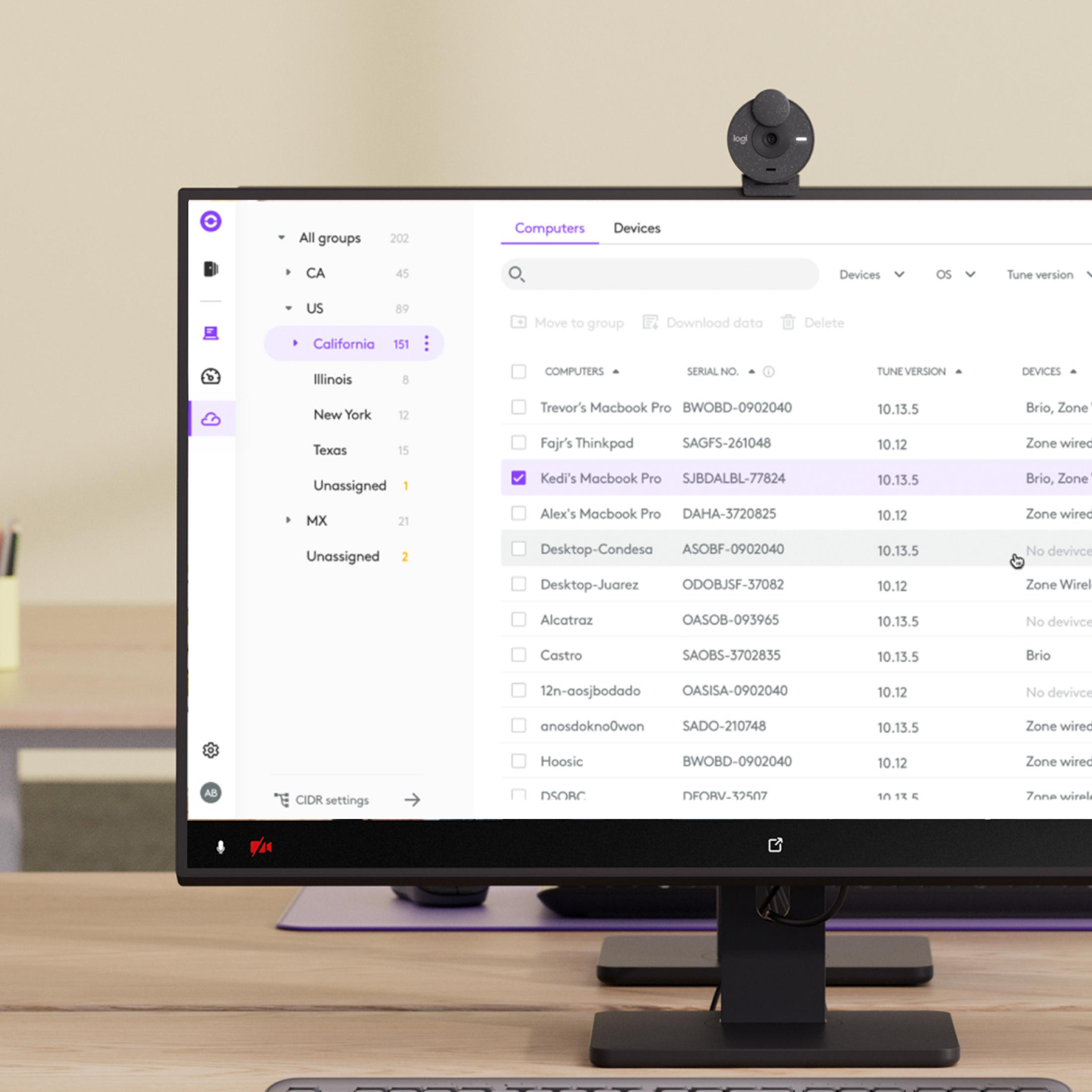 Kamera internetowa Logitech nad ekranem komputera z listą komputerów i urządzeń.