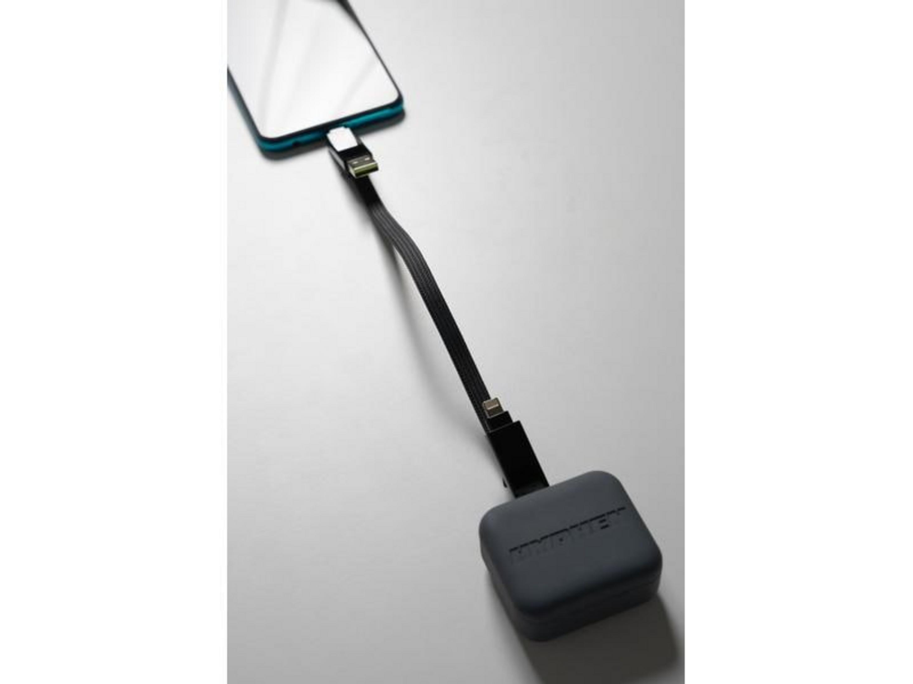 Ein Smartphone wird über ein schwarzes Kabel mit einem grauen Ladeadapter verbunden.