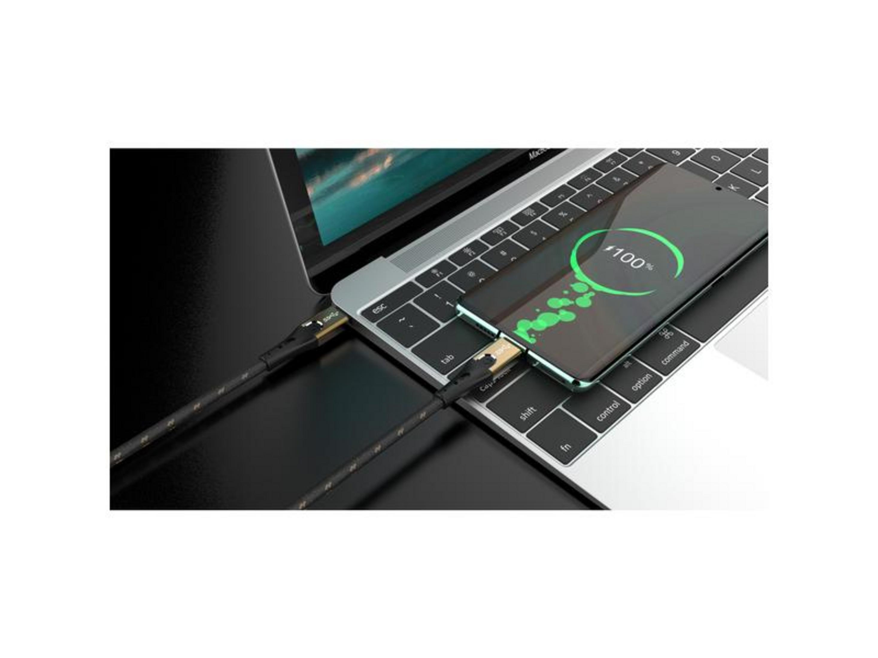 Ein Smartphone lädt auf einem Laptop, 100 % angezeigt.