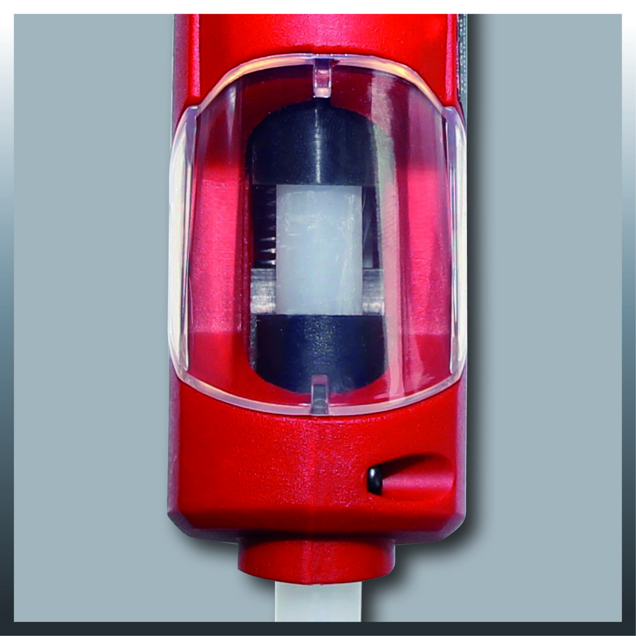 Czerwony uchwyt z przezroczystą osłoną, wewnątrz czarny i biały cylinder.