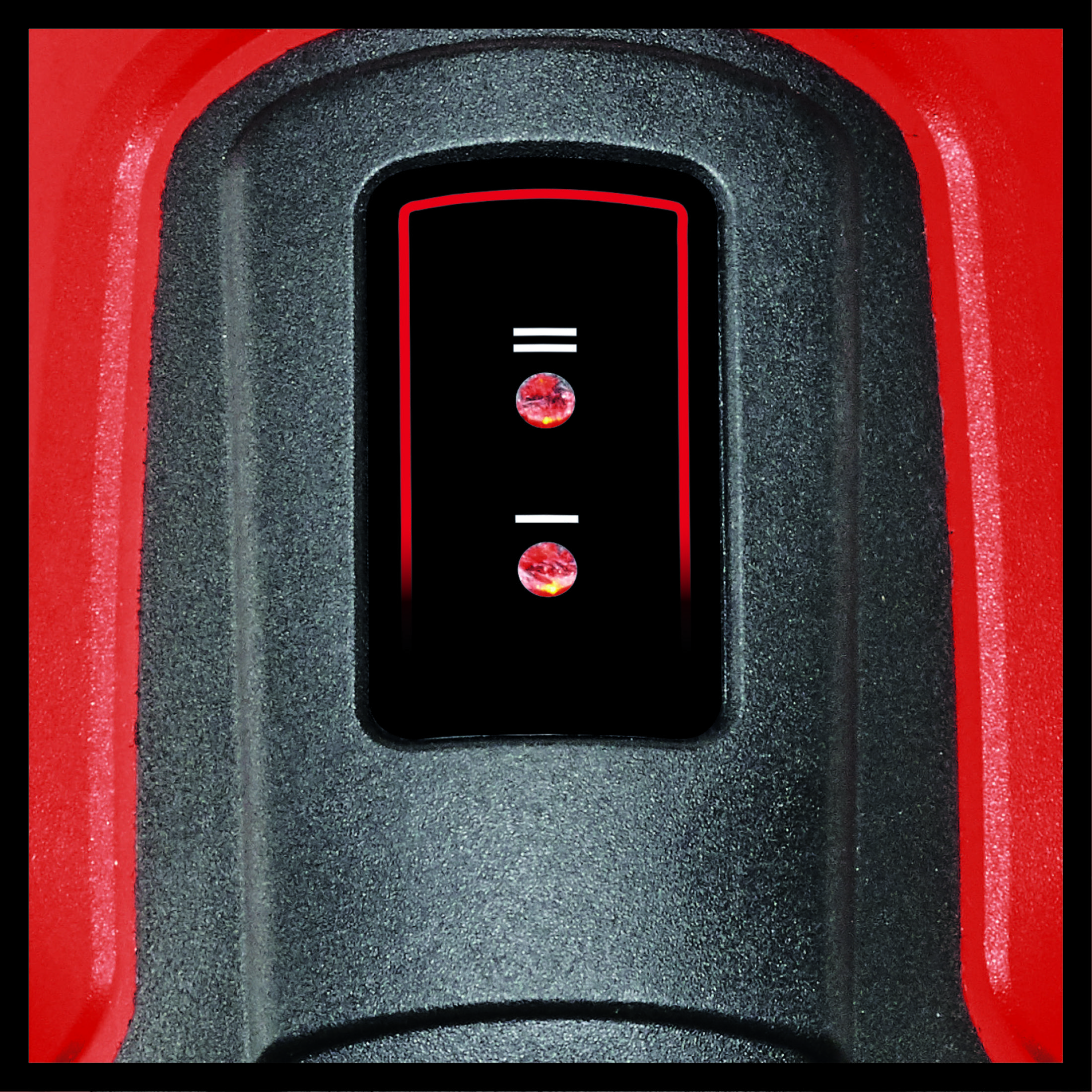 Zbliżenie czarnego panelu sterowania z czerwonymi akcentami i dwoma okrągłymi światłami.